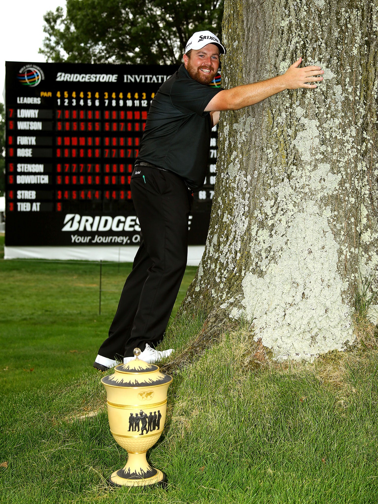 Shane Lowry hugs the tree he struck with his approach shot, for a lucky bounce which let him birdie the last and win the Bridgestone Invitational