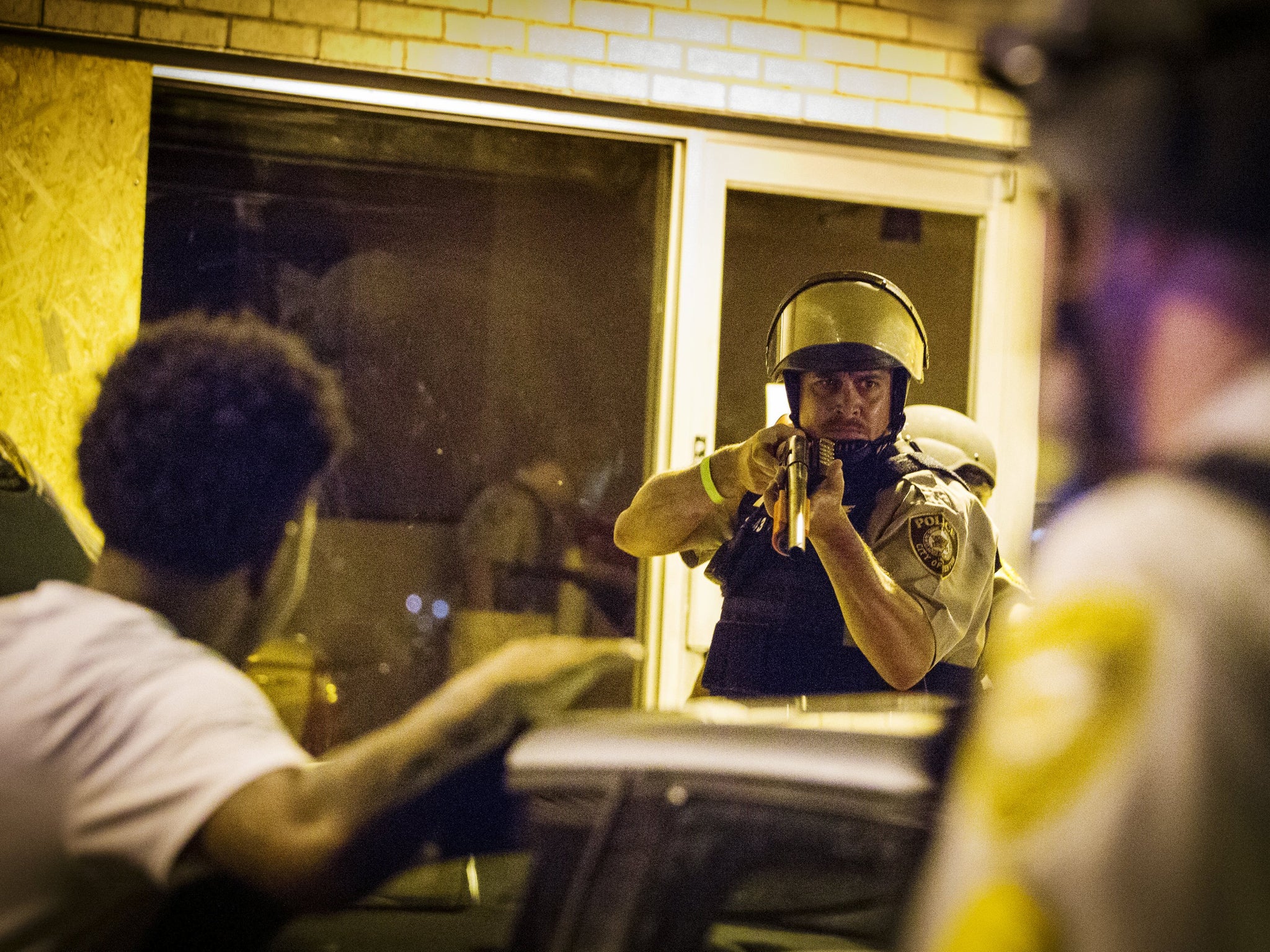 St Louis County police officers arrest an anti-police demonstrator in Ferguson, Missouri August 11, 2015