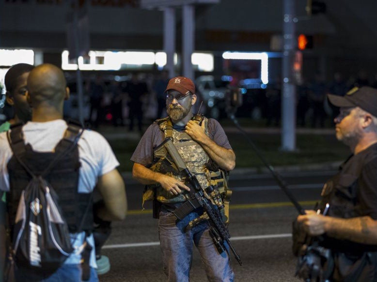 Members of the Oath Keepers walk with their personal weapons on the street during protests in Ferguson, in the early hours of 11 August