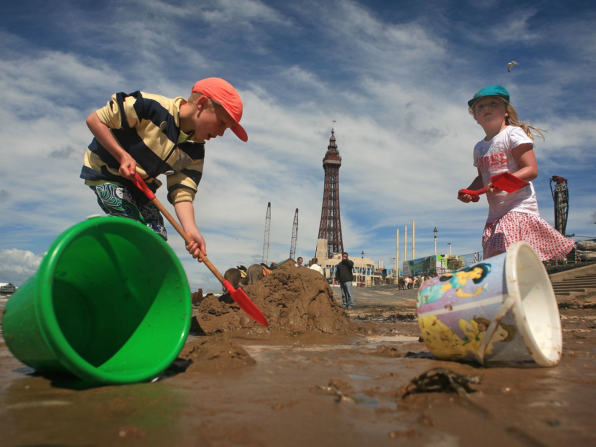 Children build a sandcastle at Blackpool beach