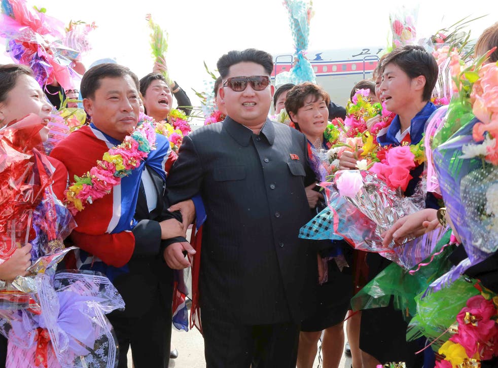 North Korean leader Kim Jong Un greets North Korea's female soccer team as they arrive at Pyongyang International Airport on Monday after winning the 2015 EAFF East Asian Cup,