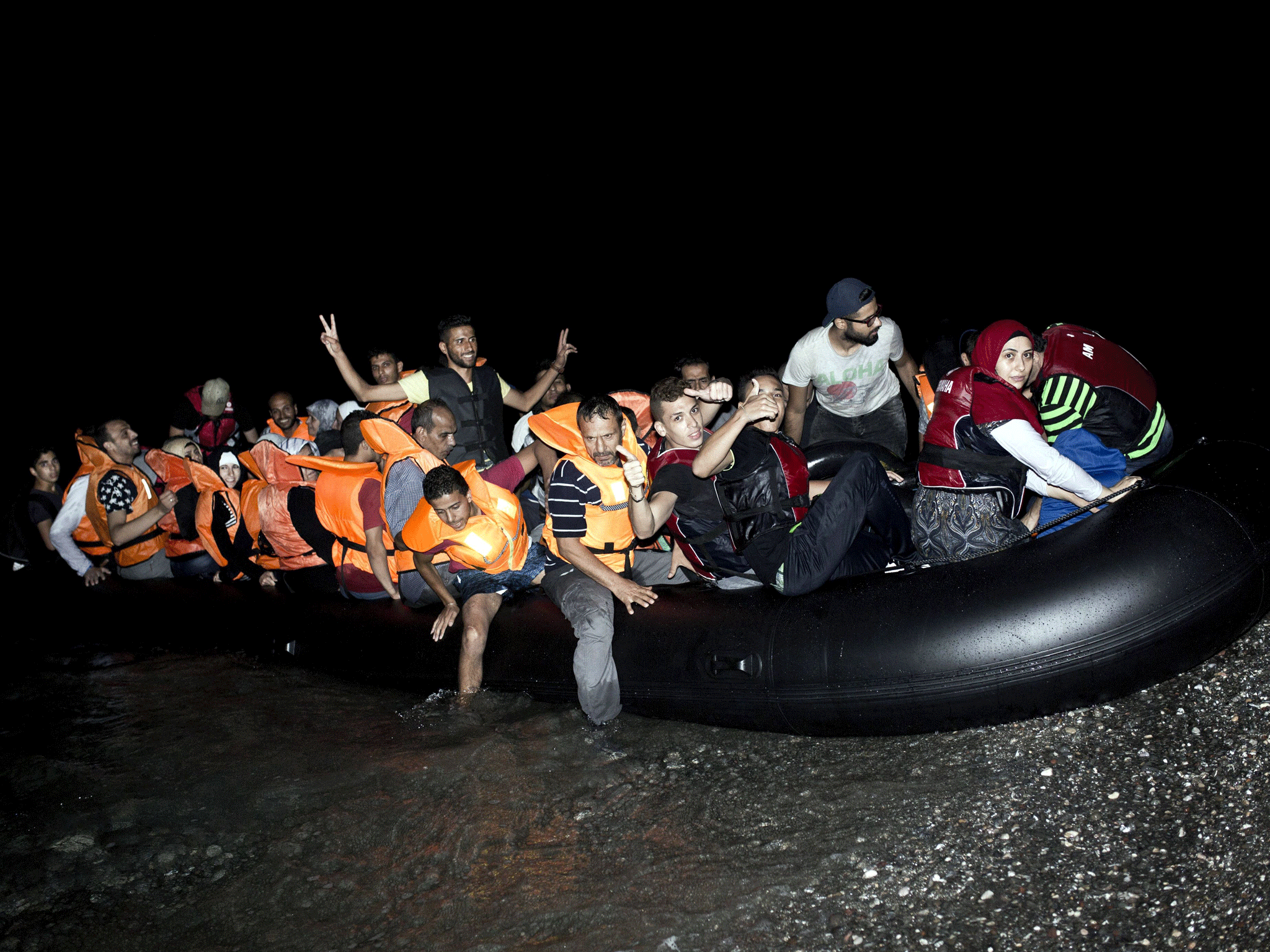 Migrants arrive in an inflatable boat on a beach on the Greek island of Kos (AFP PHOTO / ANGELOS TZORTZINIS)