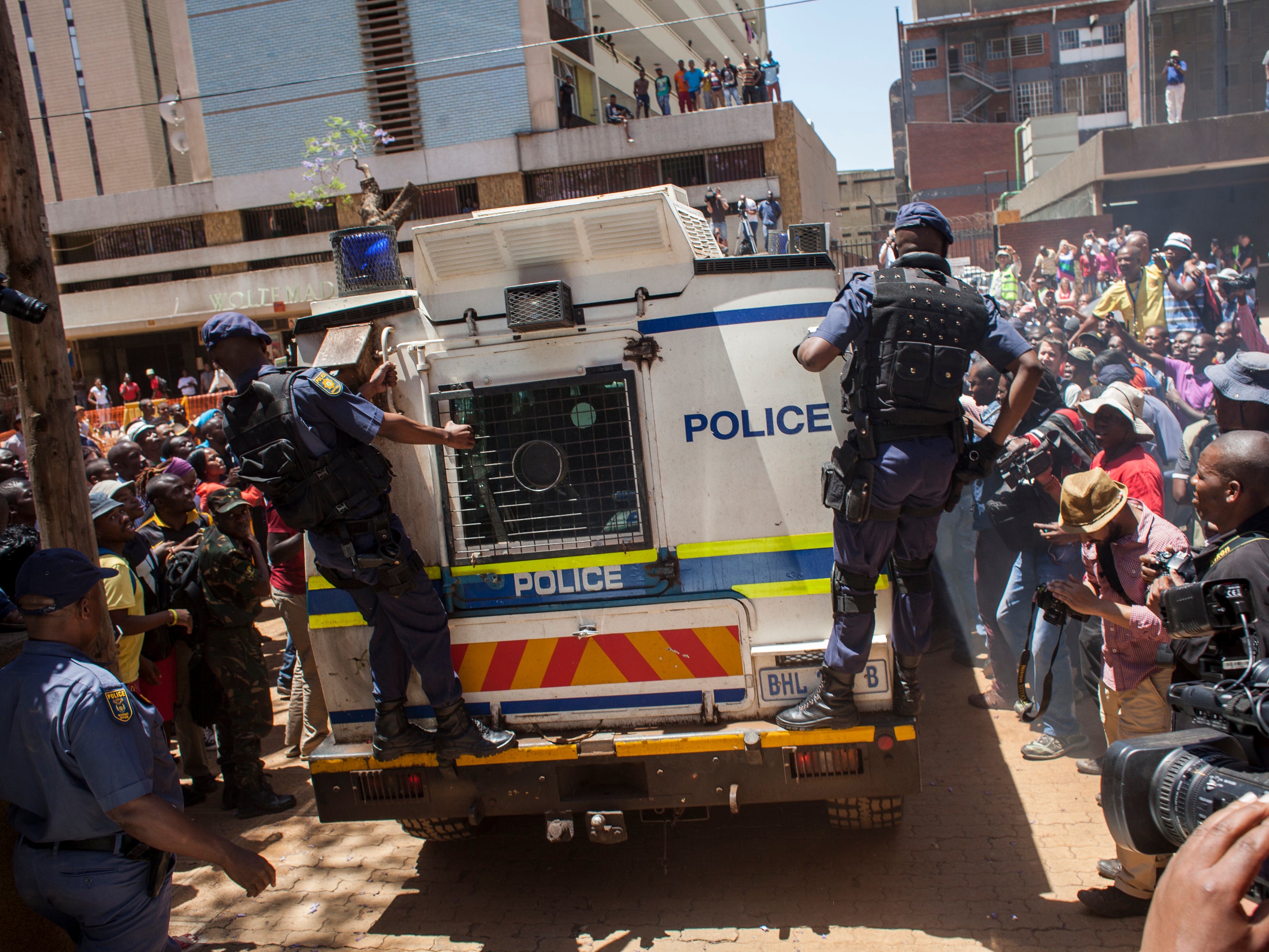 Crowds surrounding a police convoy escorting Pistorius to a prison in Pretoria on October 21, 2014.