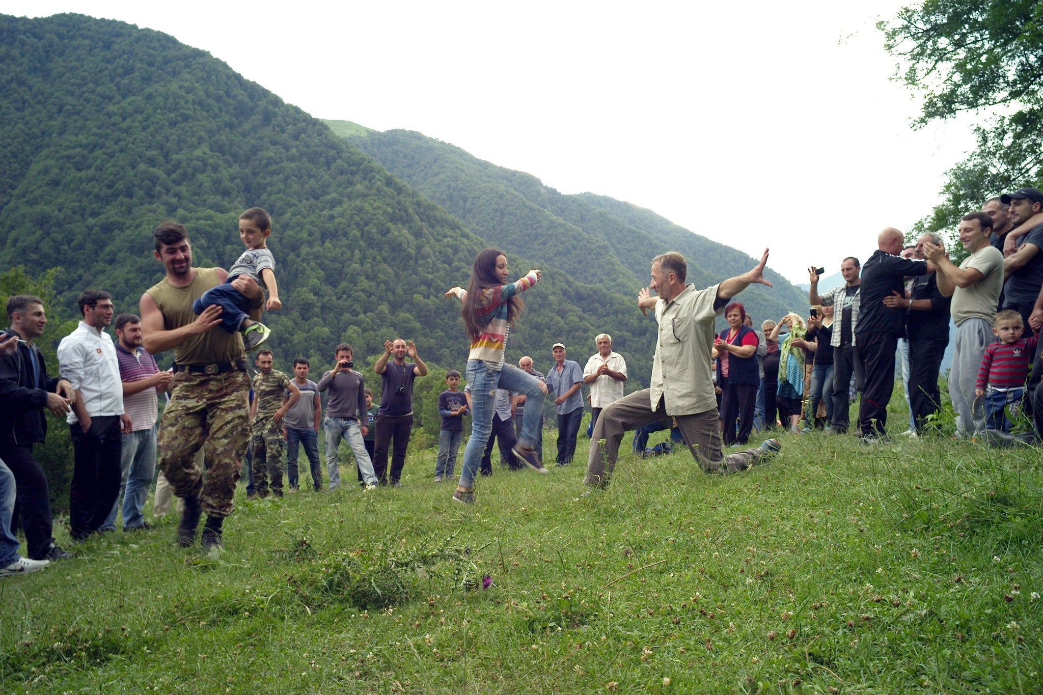 Villagers gather to dance on the hillside