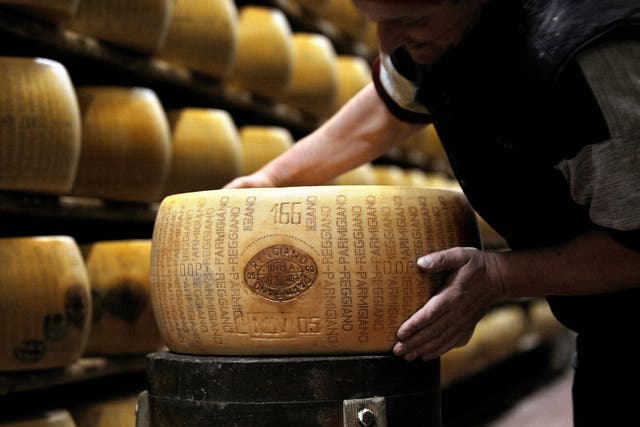  A picture taken on February 15, 2008 shows a worker checking a wheel of seasoned Parmigiano Reggiano cheese in a factory in Valestra, near Reggio Emilia