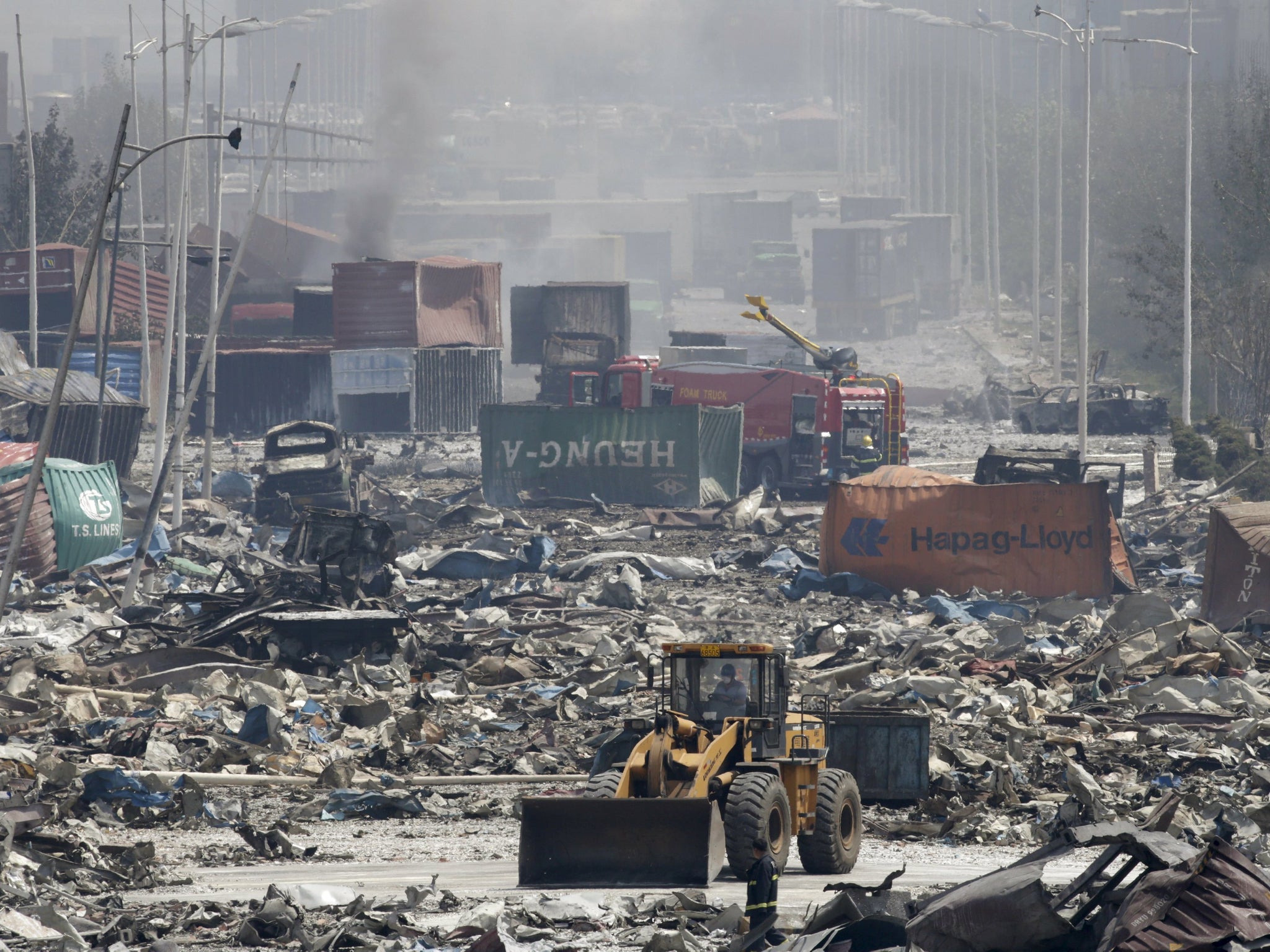 Excavators work near the site of the explosions at the Binhai new district, Tianji
