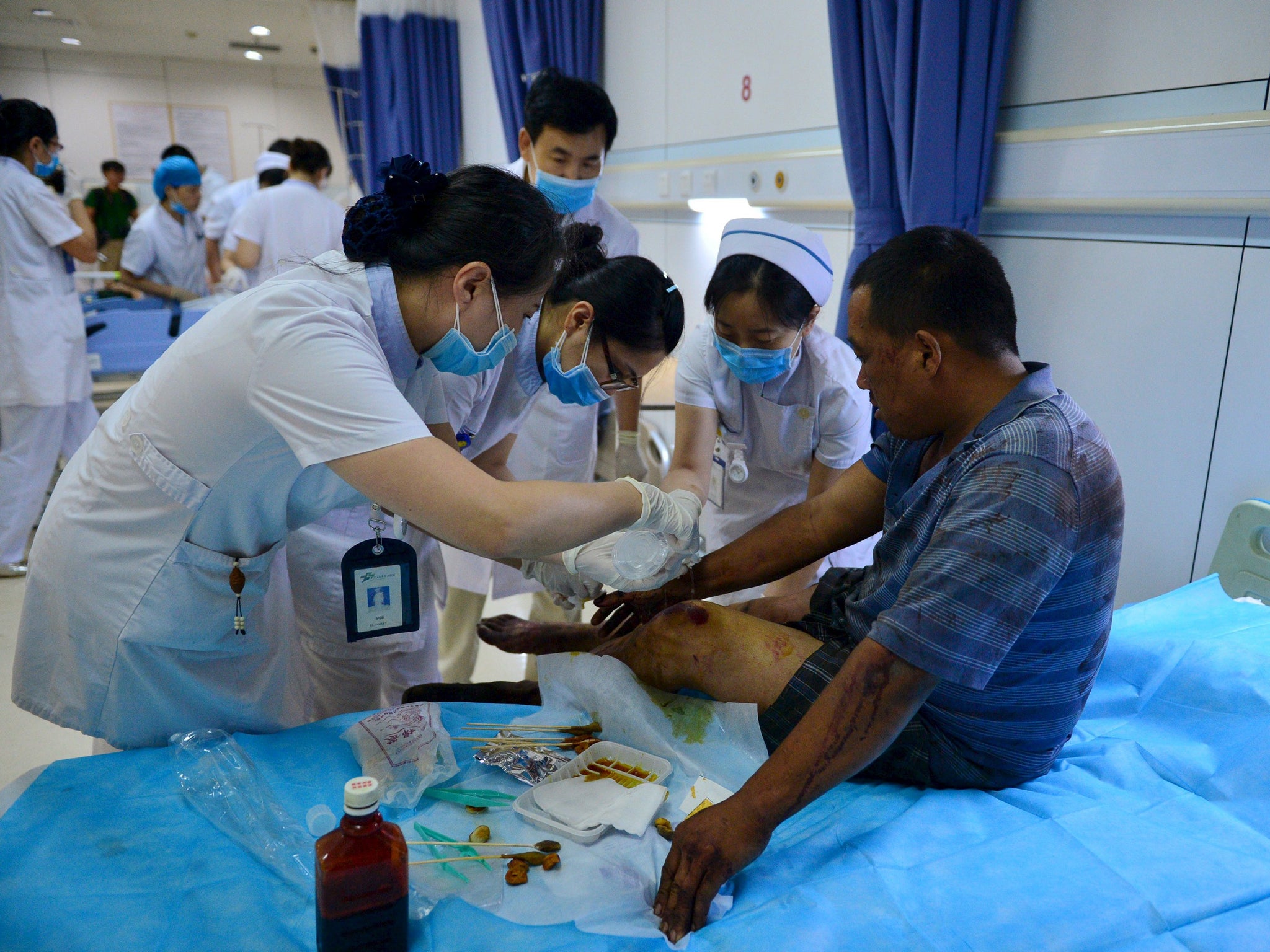 A man who was injured following the massive explosions at the Binhai new district in Tianjin receives medical treatment at a hospital.