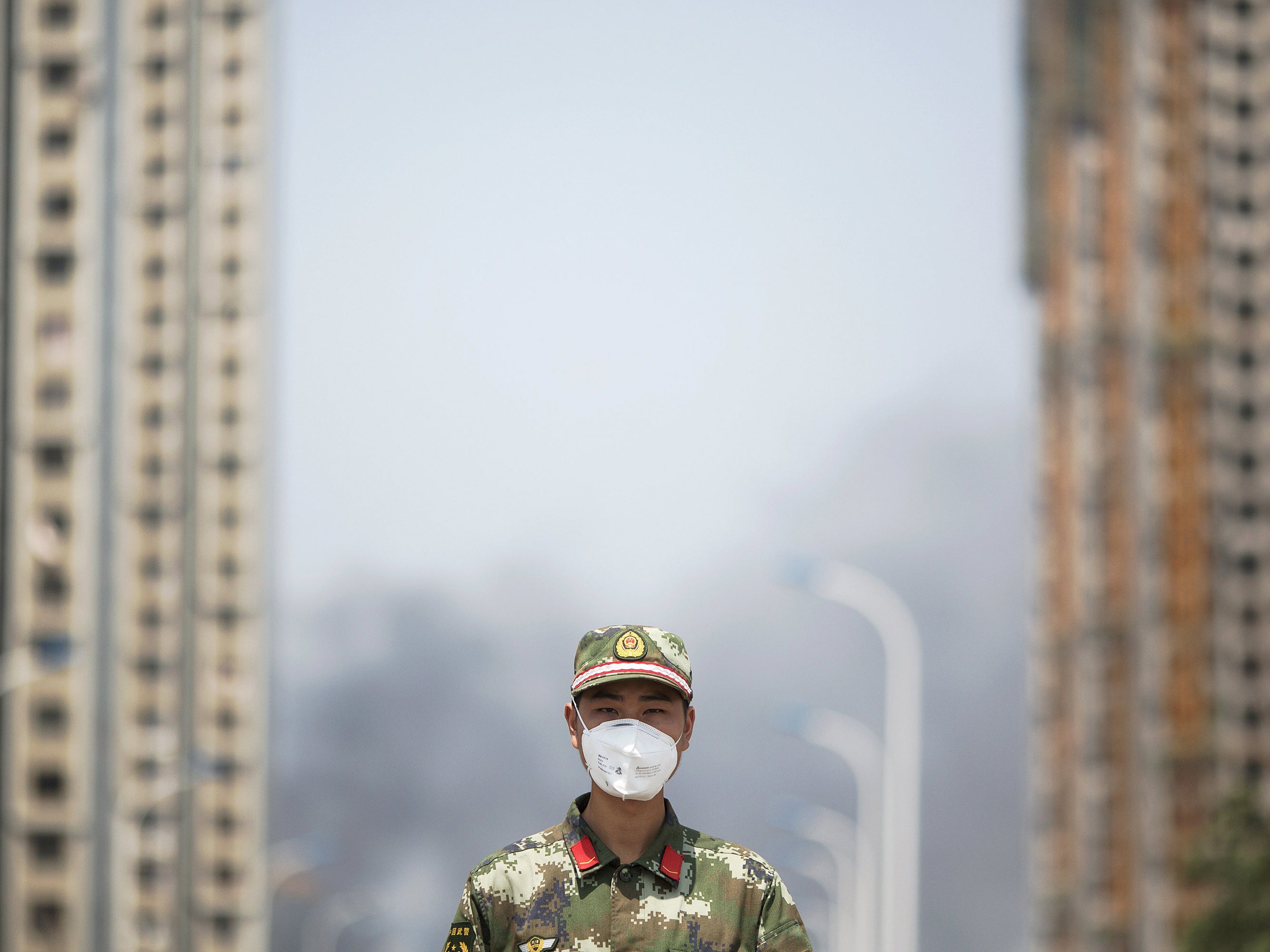 A paramilitary policeman wears a mask as he blocks the road leading to evacuated residential area and the explosion site in Binhai new district in Tianjin