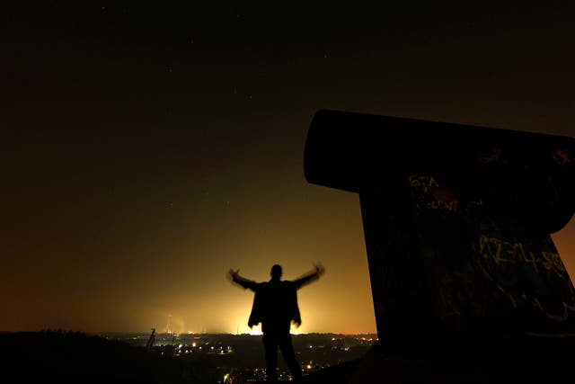 A man waits for the Perseid meteor shower at night on a mining dump in Gelsenkirchen, western Germany
