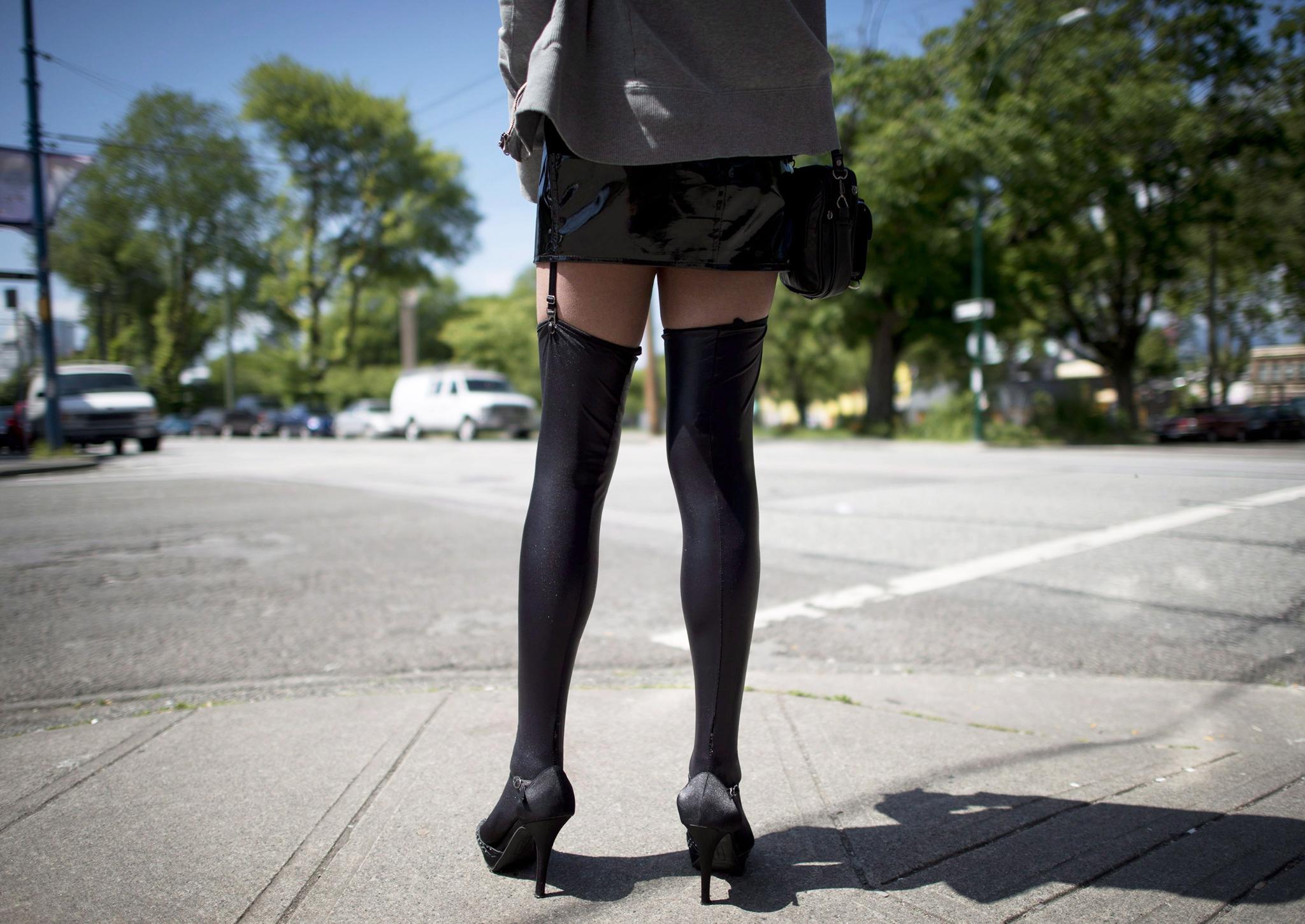 A sex trade worker stands on a corner in downtown Vancouver