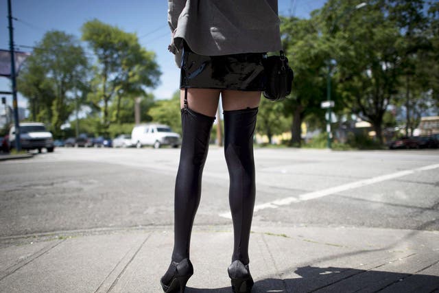 A sex trade worker stands on a corner in downtown Vancouver