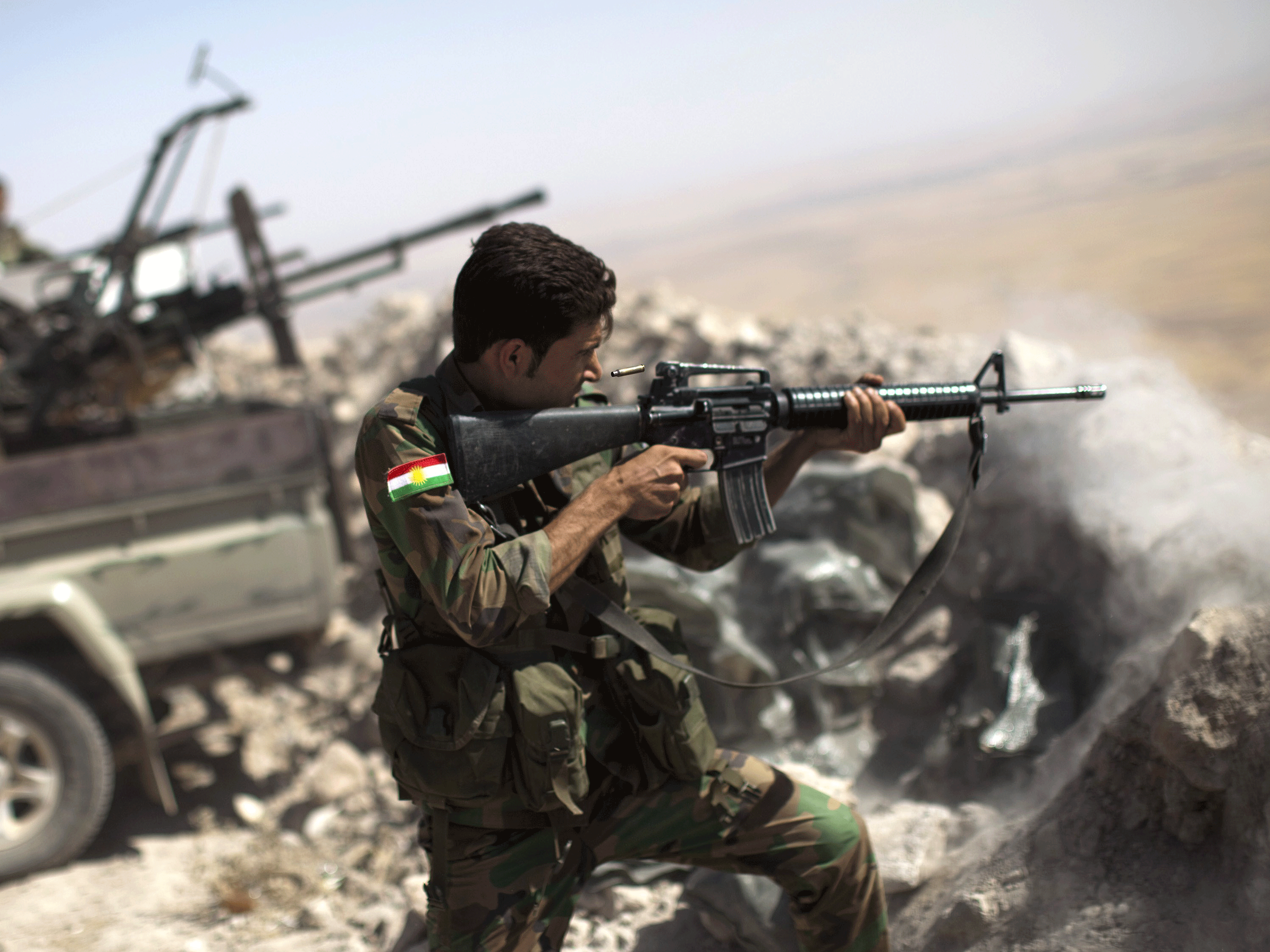 An Iraqi Kurdish peshmerga fighter fires on an Isis position