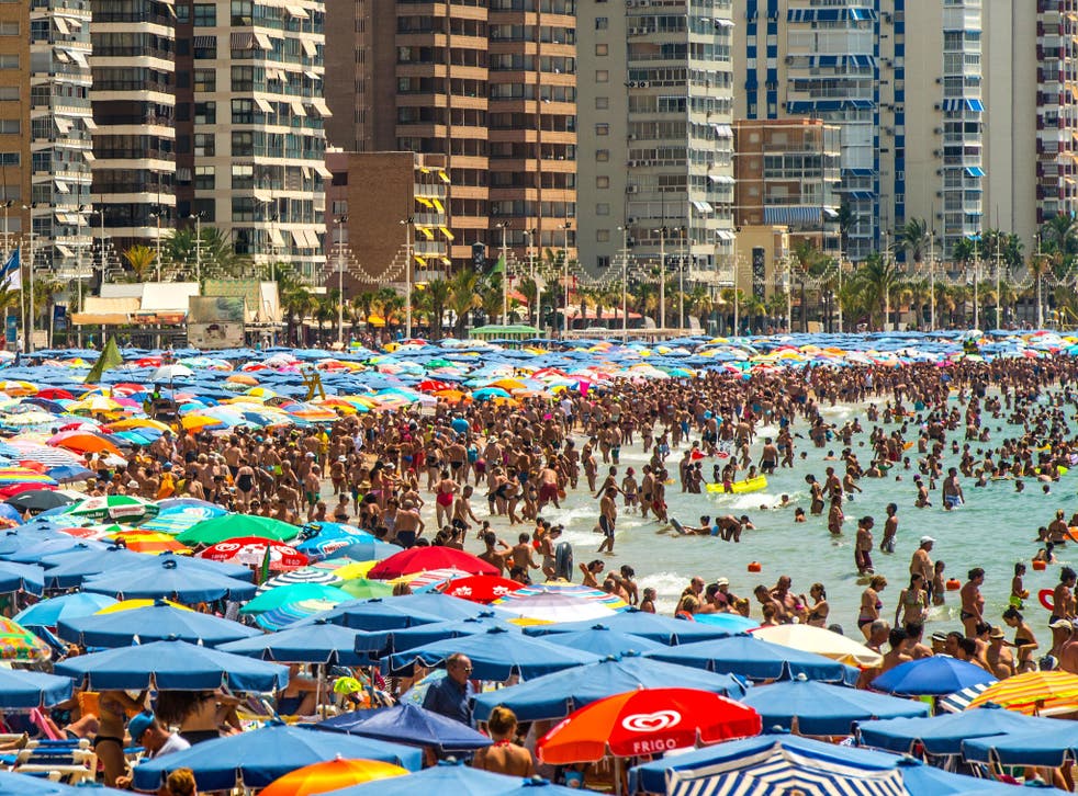 Crowds sunbathe at Levante beach in Benidorm, Spain