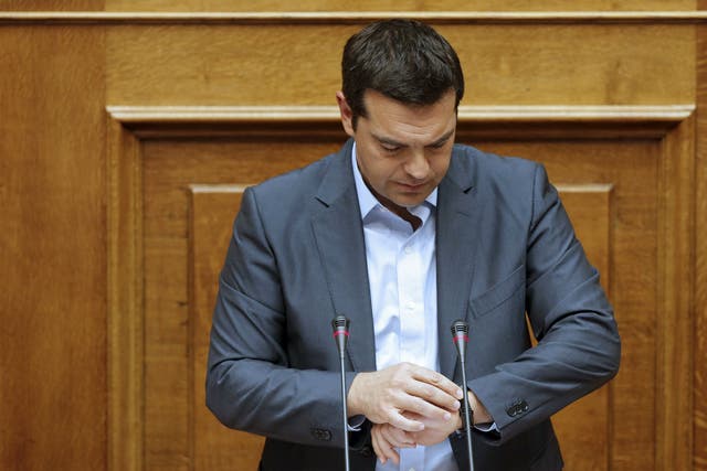 Greek Prime Minister Alexis Tsipras checks his watch as he delivers his speech at the end of a night parliamentary session in Athens, Greece, August 14, 2015 (REUTERS/Christian Hartmann)