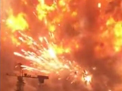 An industrial crane appeared miniscule against the huge explosion