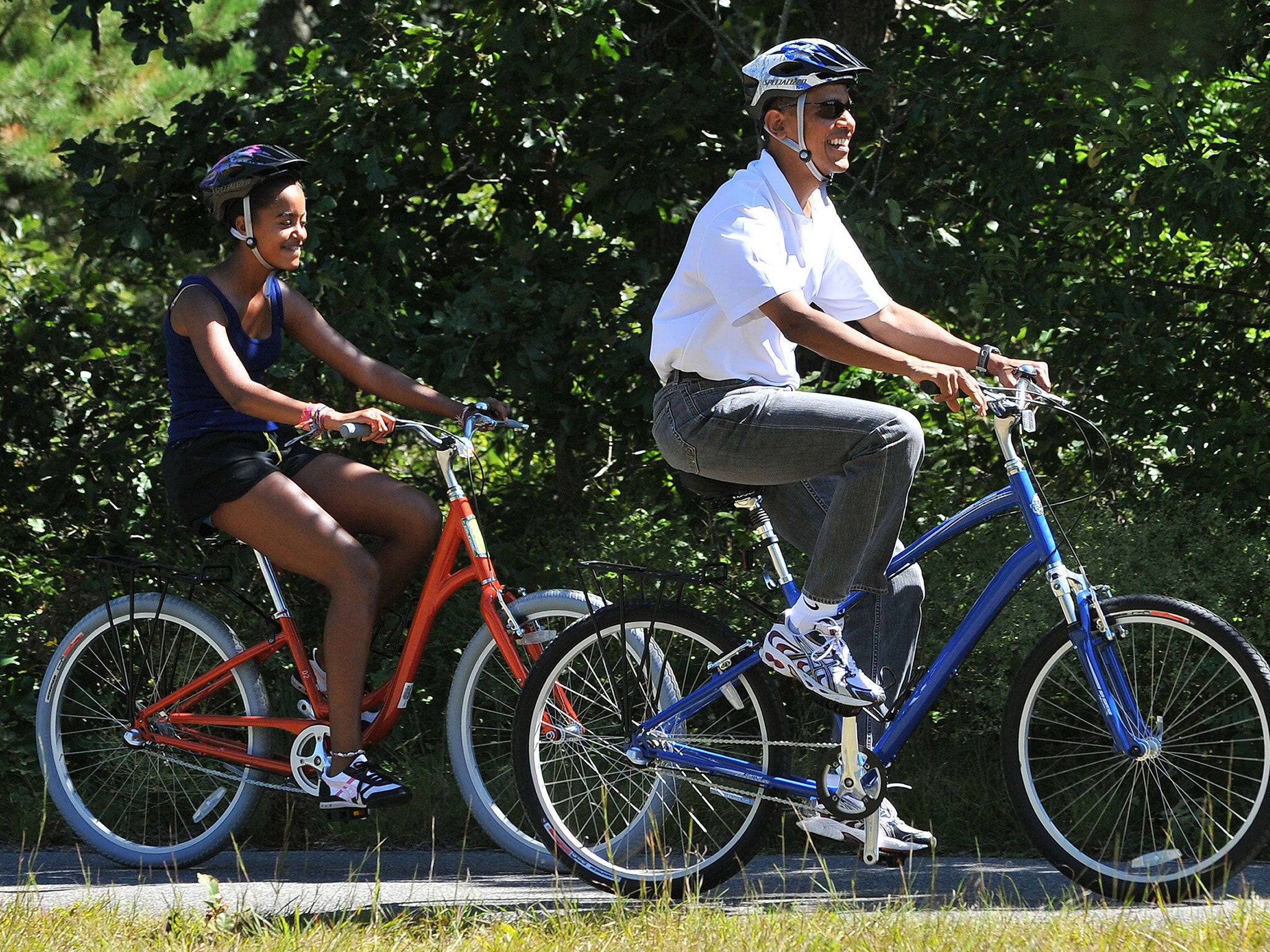 Barack Obama rides his bicycle with daughter Malia on Martha's Vineyard on 2010