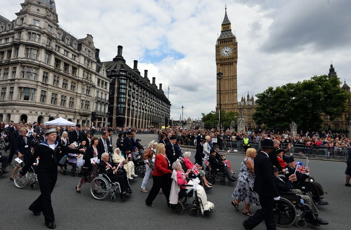 Veterans and serving members of the British Armed Forces march past Big Ben on VJ Day