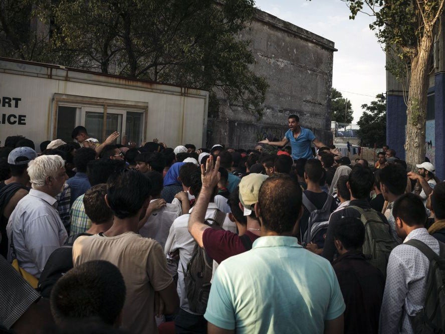 Migrants wait to register with the police authorities in Mytilene on Lesbos island, on August 14, 2015.