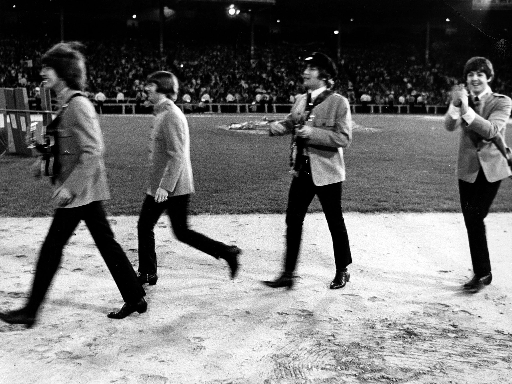 The Beatles on stage arriving at Shea Stadium
