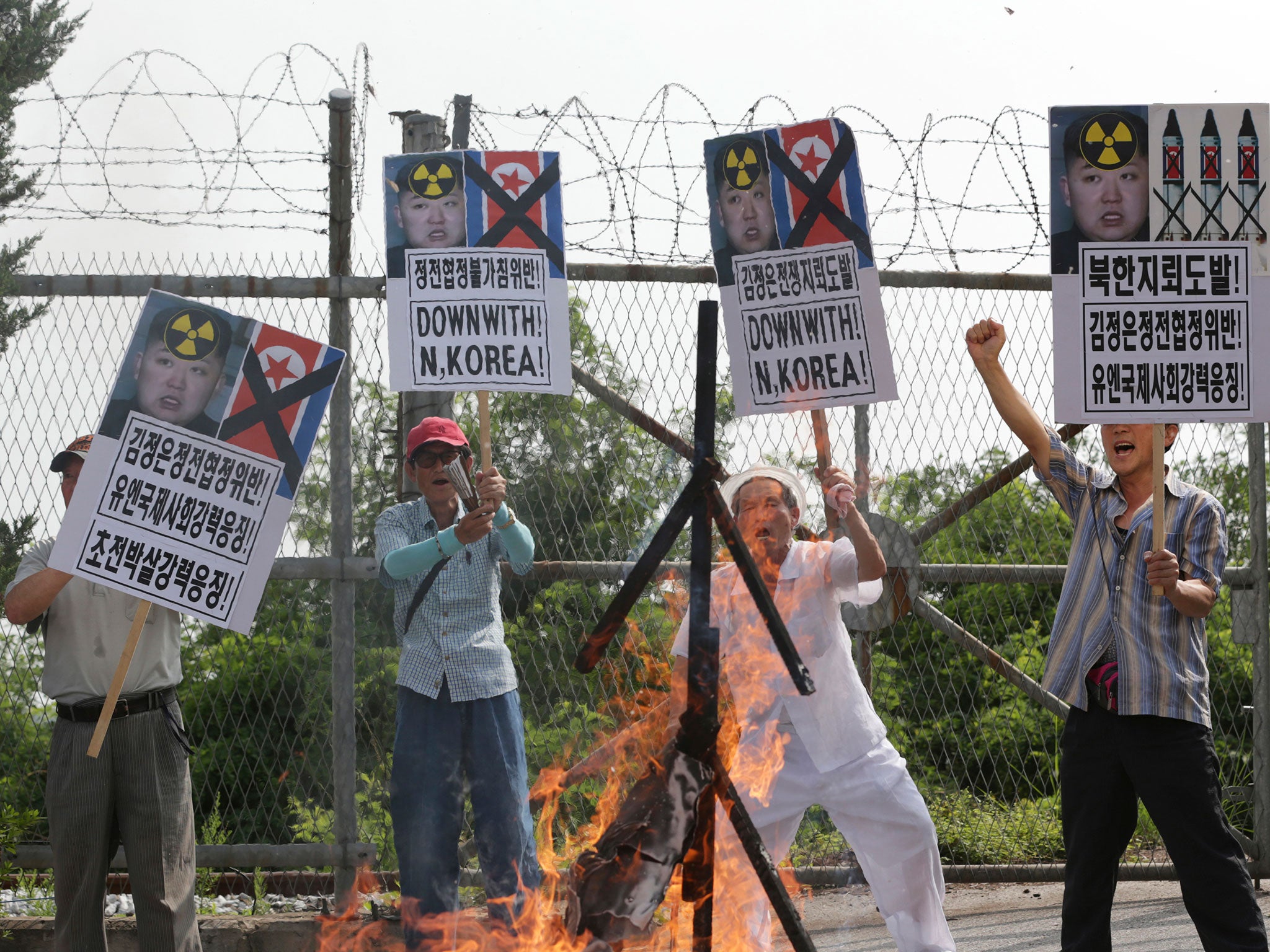 Members of South Korean conservative group shout slogans after burning an effigy of North Korean leader Kim Jong Un and North Korean flags during a rally denouncing the North