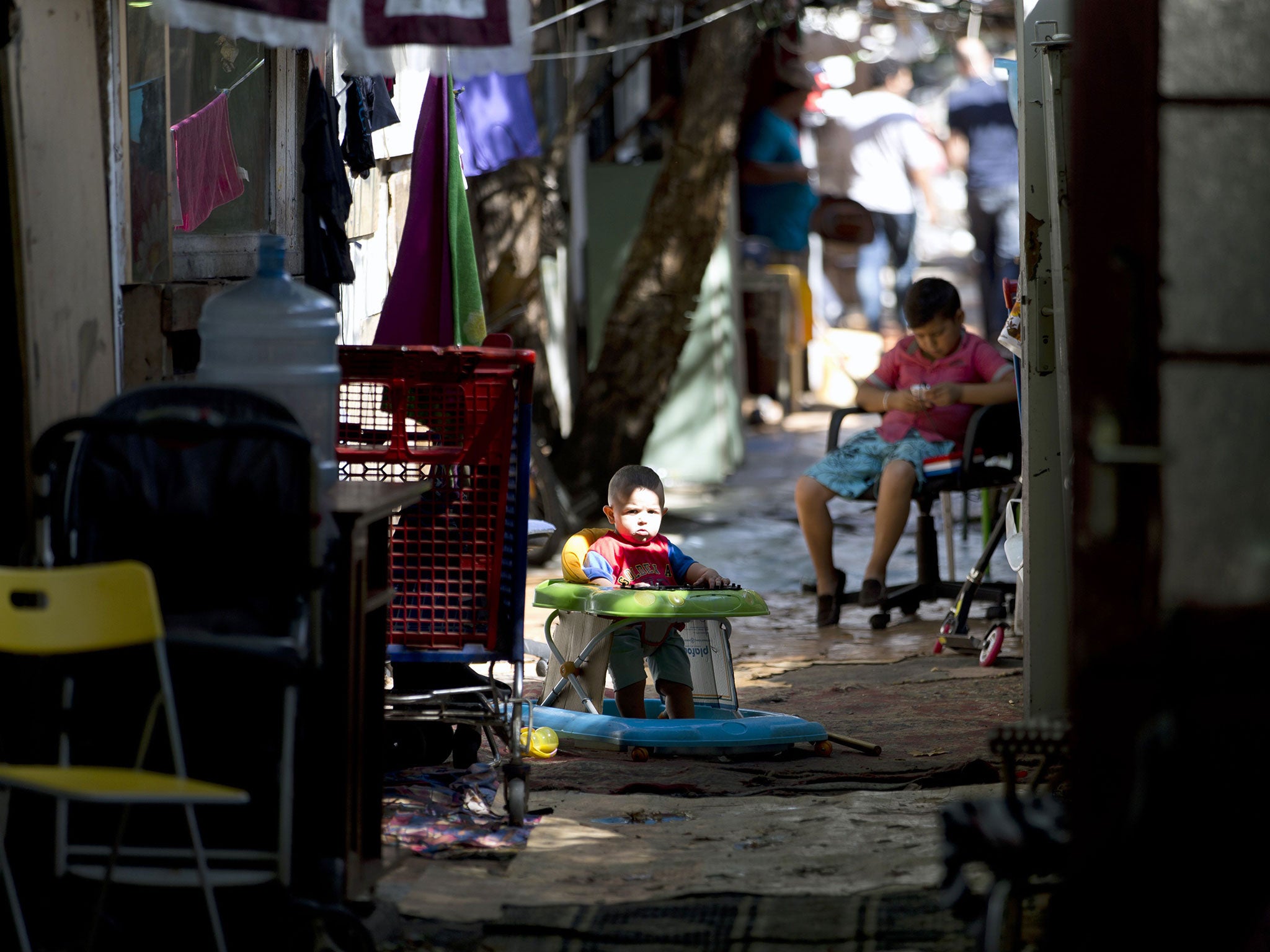 Children sit in a walkway inside the Samaritan shantytown. Volunteer groups have offered to improve sanitation and safety in the settlement but the council says their plans are not viable