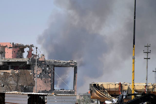 Smoke rises above a damaged building following a U.S.-led coalition airstrike against Islamic State group positions during a military operation to regain control of the eastern suburbs of Ramadi, in Anbar province, Iraq