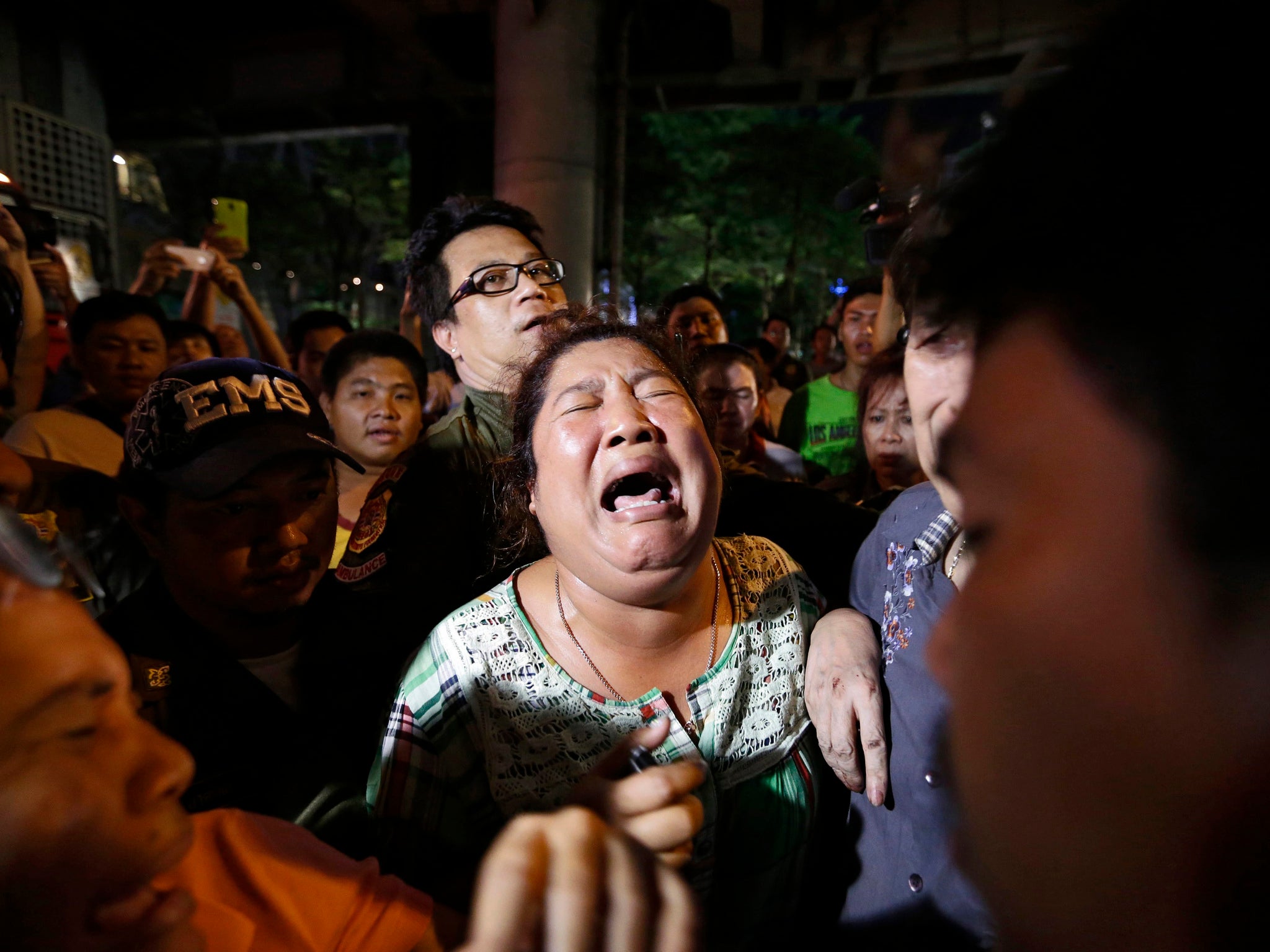 A woman is deeply distressed as crowds await news on their missing relatives (EPA)