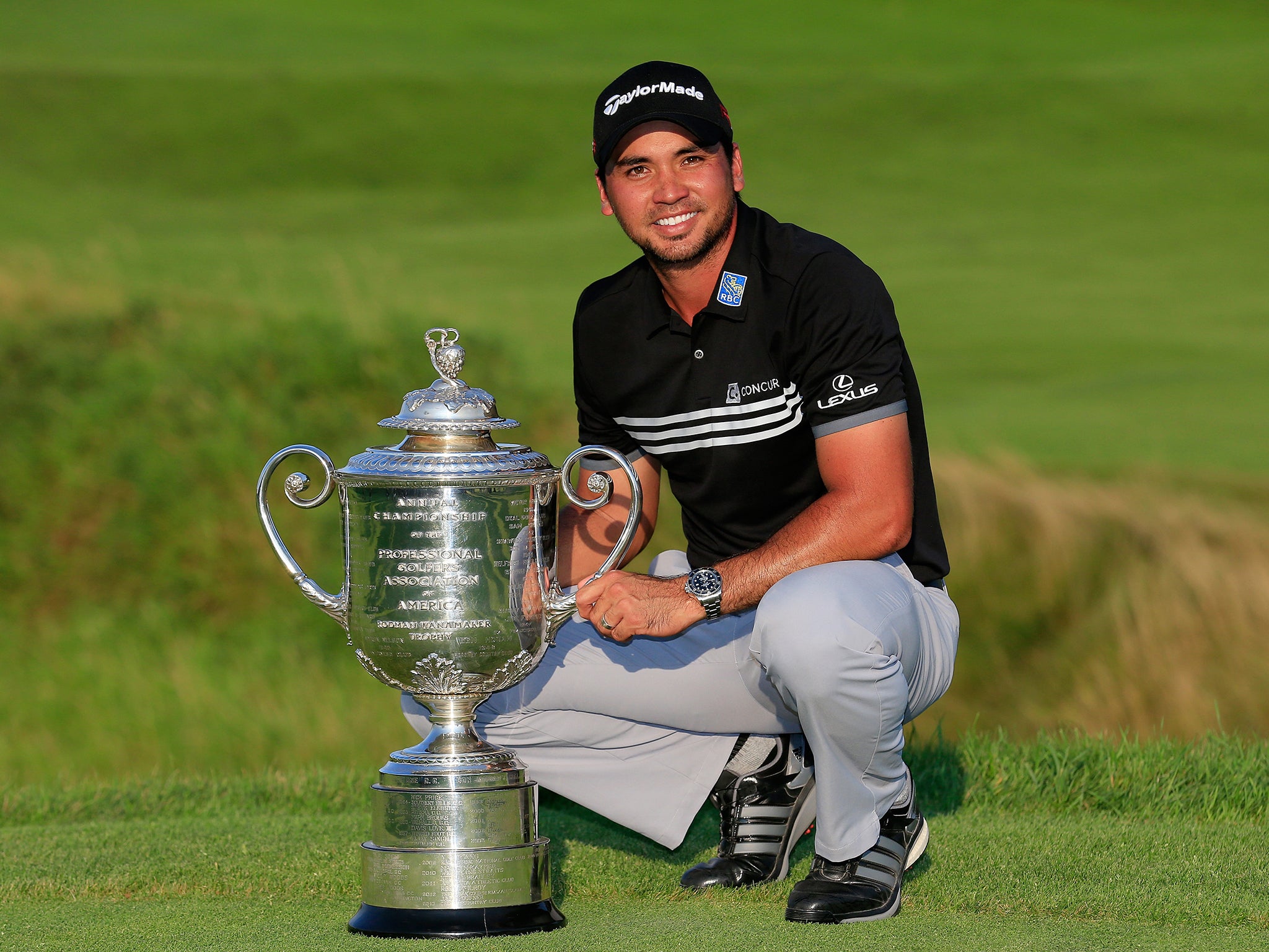 Jason Day poses with the trophy