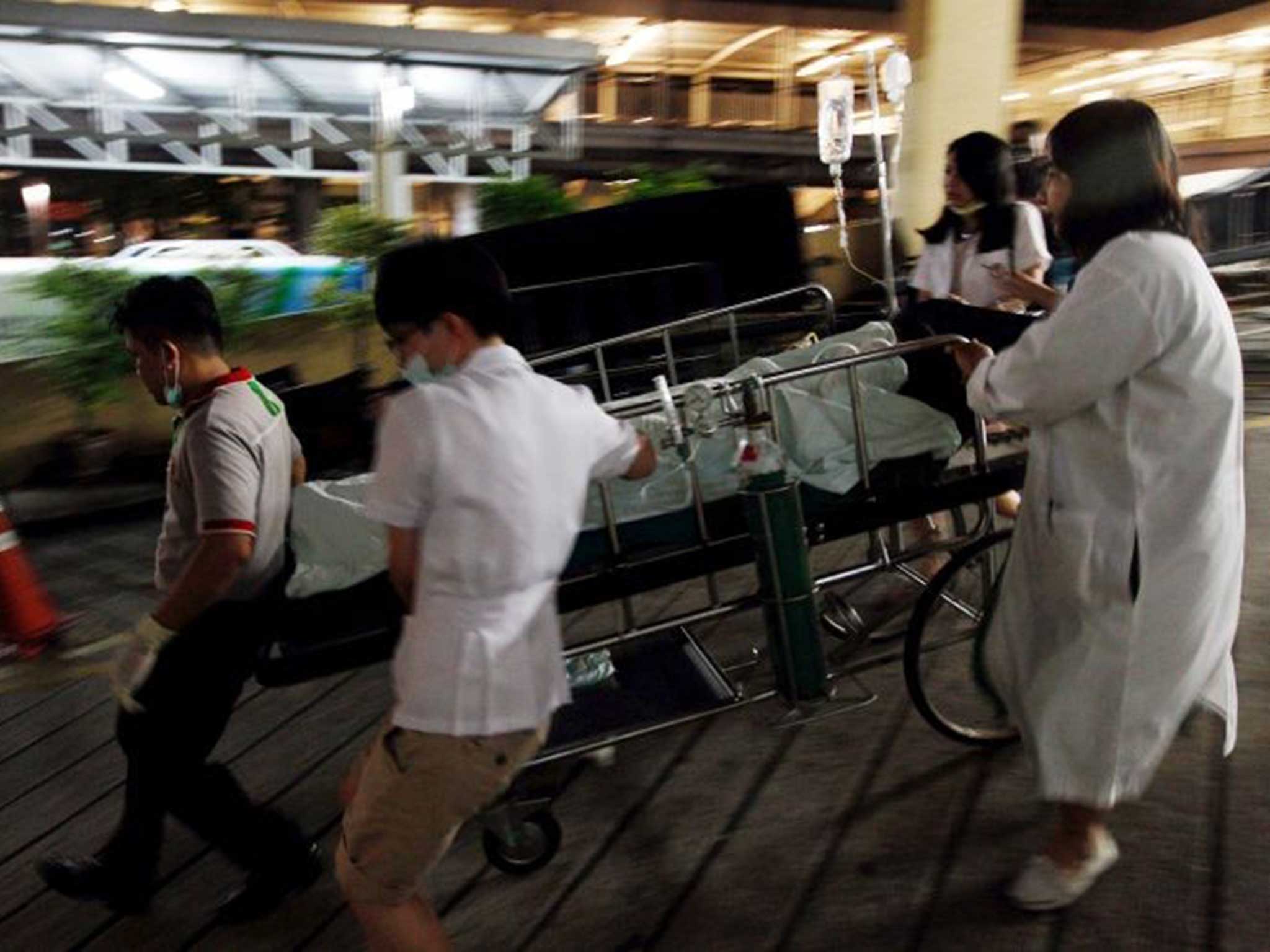 Doctors rush a victim injured in the Bangkok bomb blast into hospital