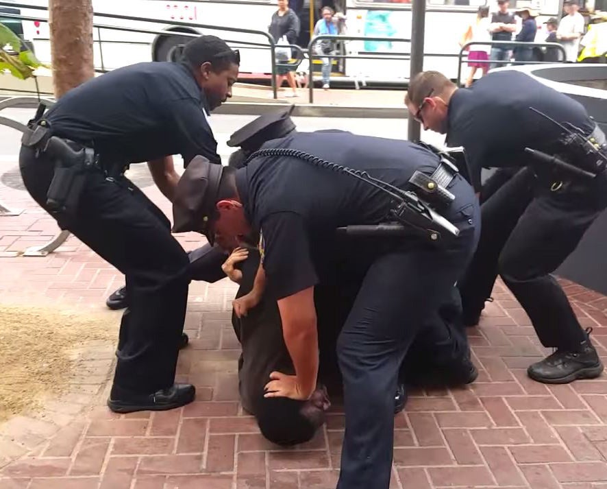 The man was seen being pinned to the ground by five police officers
