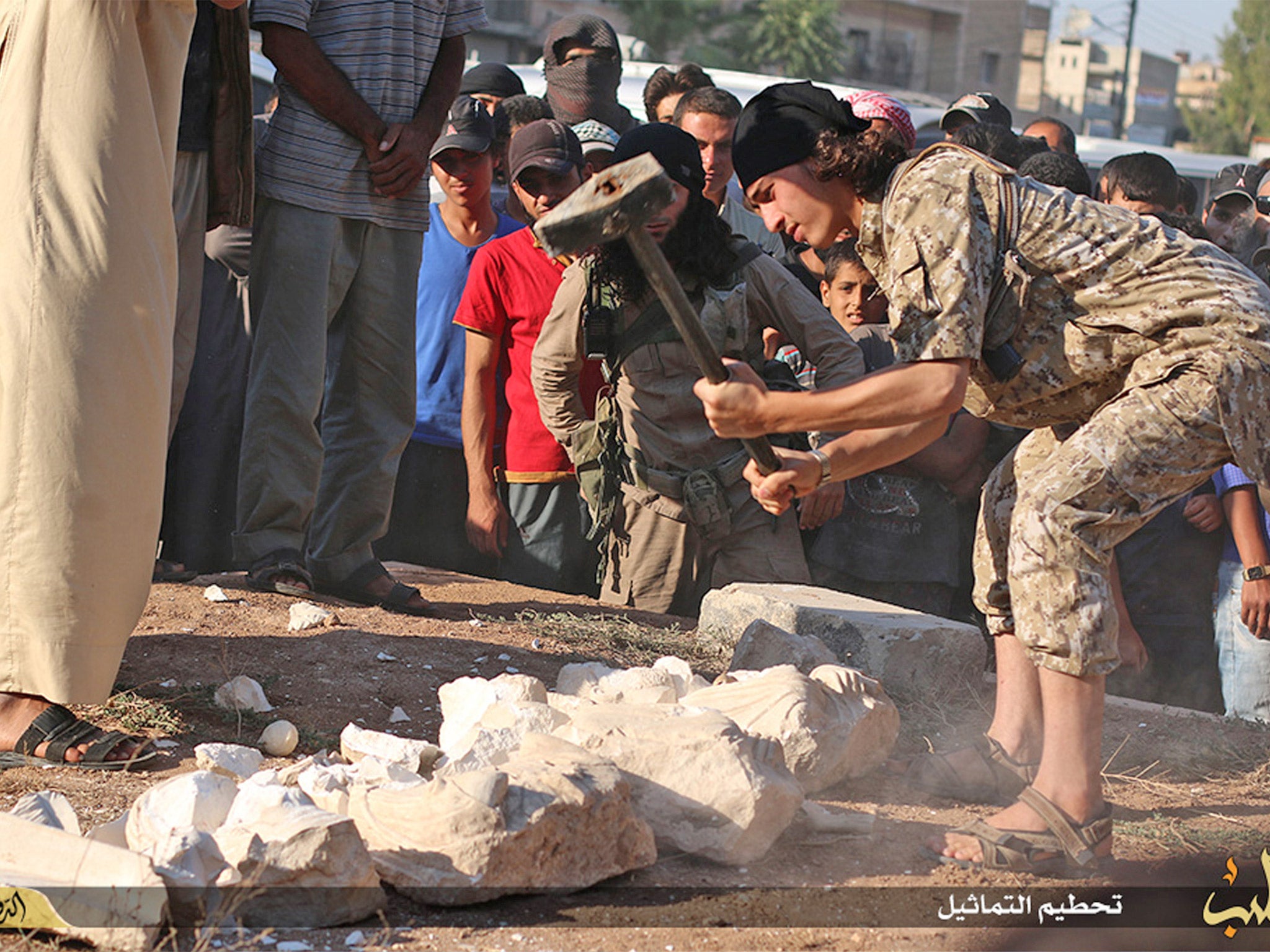 An image posted on an Isis affiliated website shows a militant smashing items from Palmyra