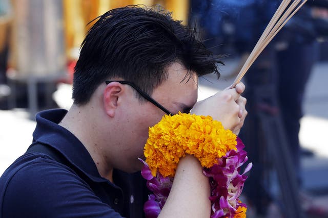 A man prays before the sacred Erawan Shrine, as it reopens to the public in Bangkok