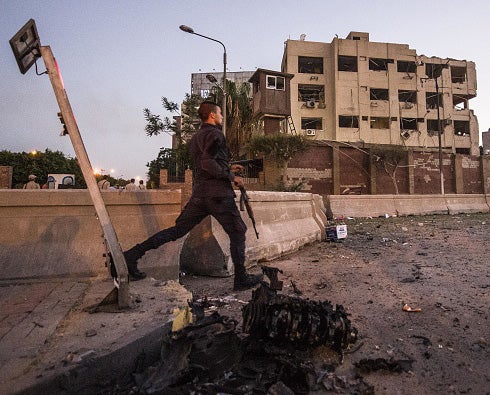 A soldier walks past the damaged security building in Cairo