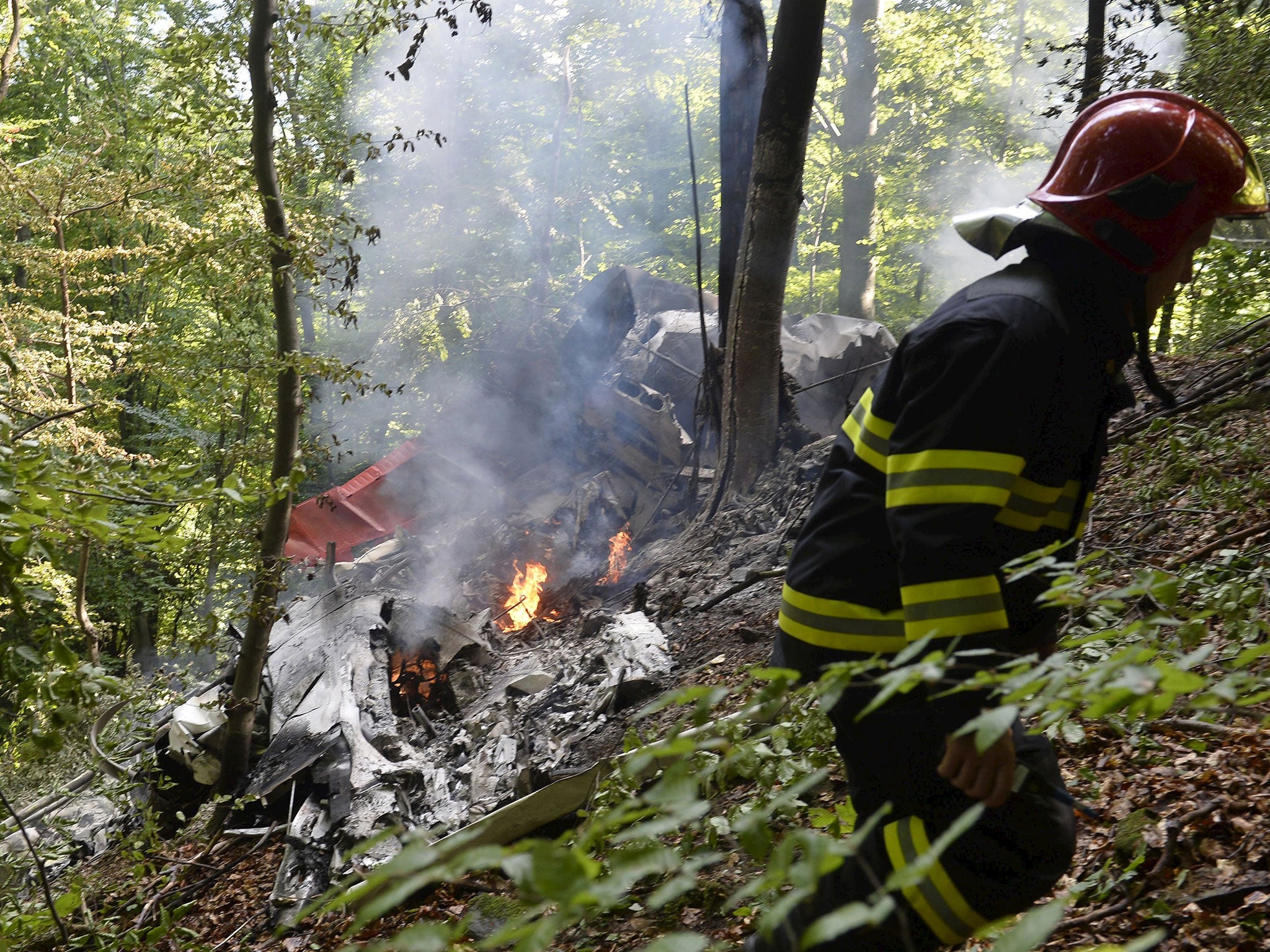 A firefighter inspects the crash site of two sport planes near the village of Cerveny Kamen, Slovakia, August 20, 2015