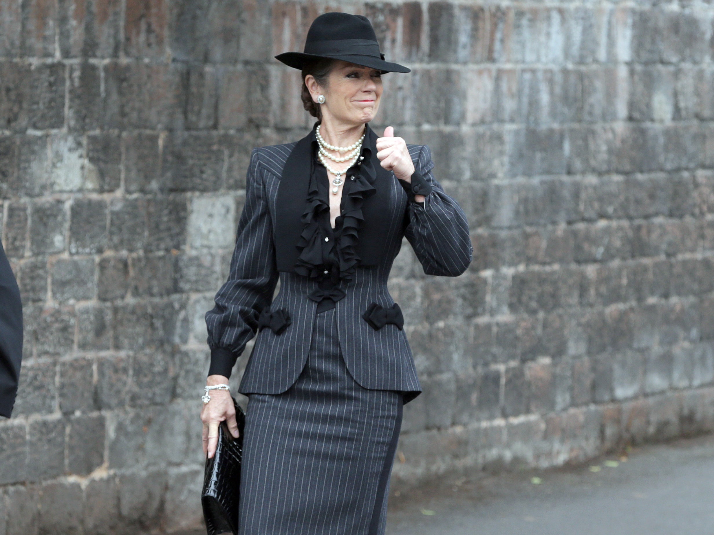 British actress Lorraine Chase arrives at the church during the funeral