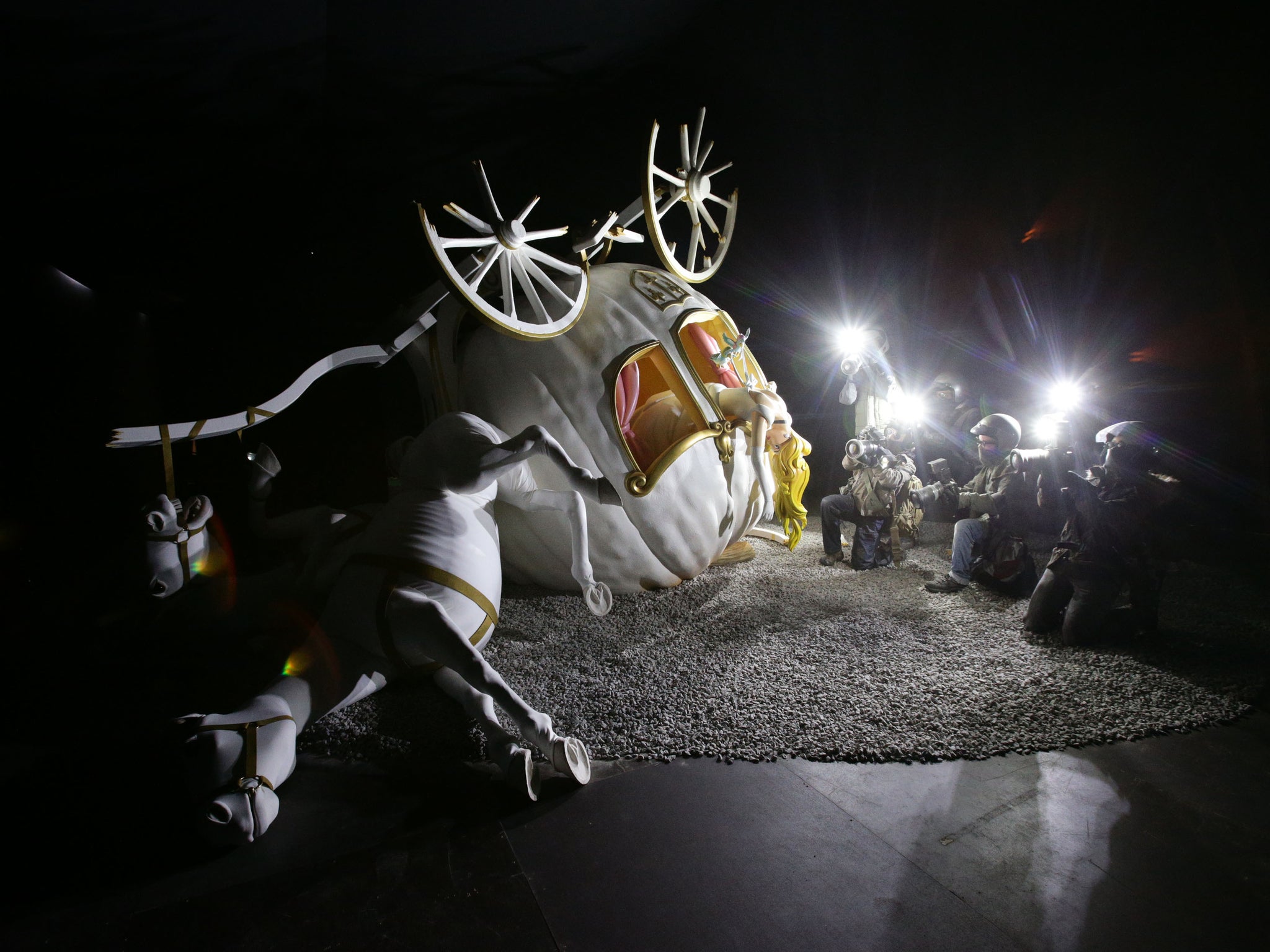 A piece by Banksy depicting Cinderella falling from her pumpkin carriage goes on display during the press view of Dismaland