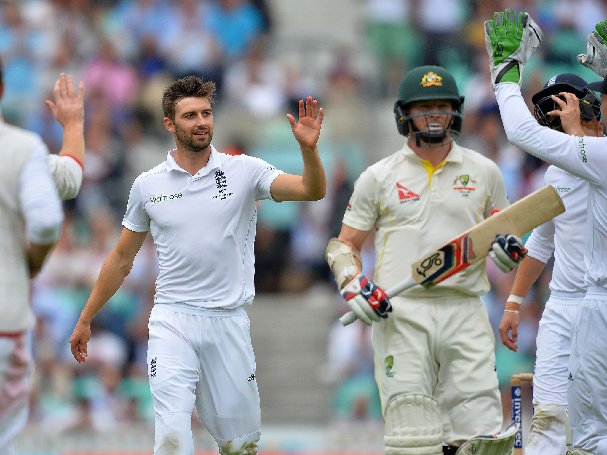 Mark Wood celebrates the wicket of Chris Rogers (right)