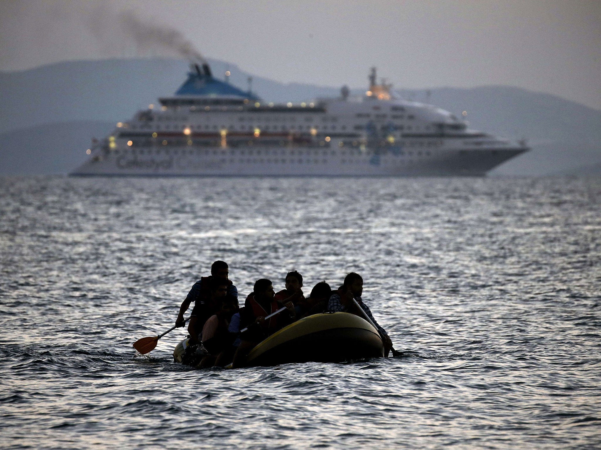 Migrants arrive on the shore of Kos island on a small dinghy in August