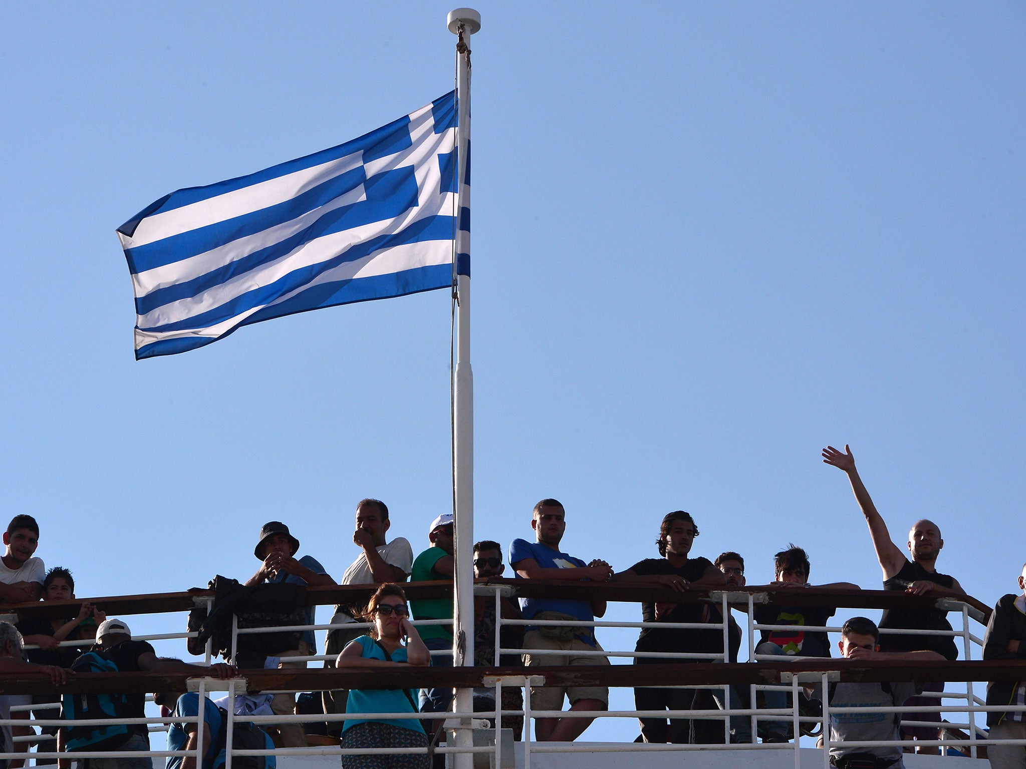 Syrian refugees stand on the deck of Greek government-chartered Eleftherios Venizelos ferry