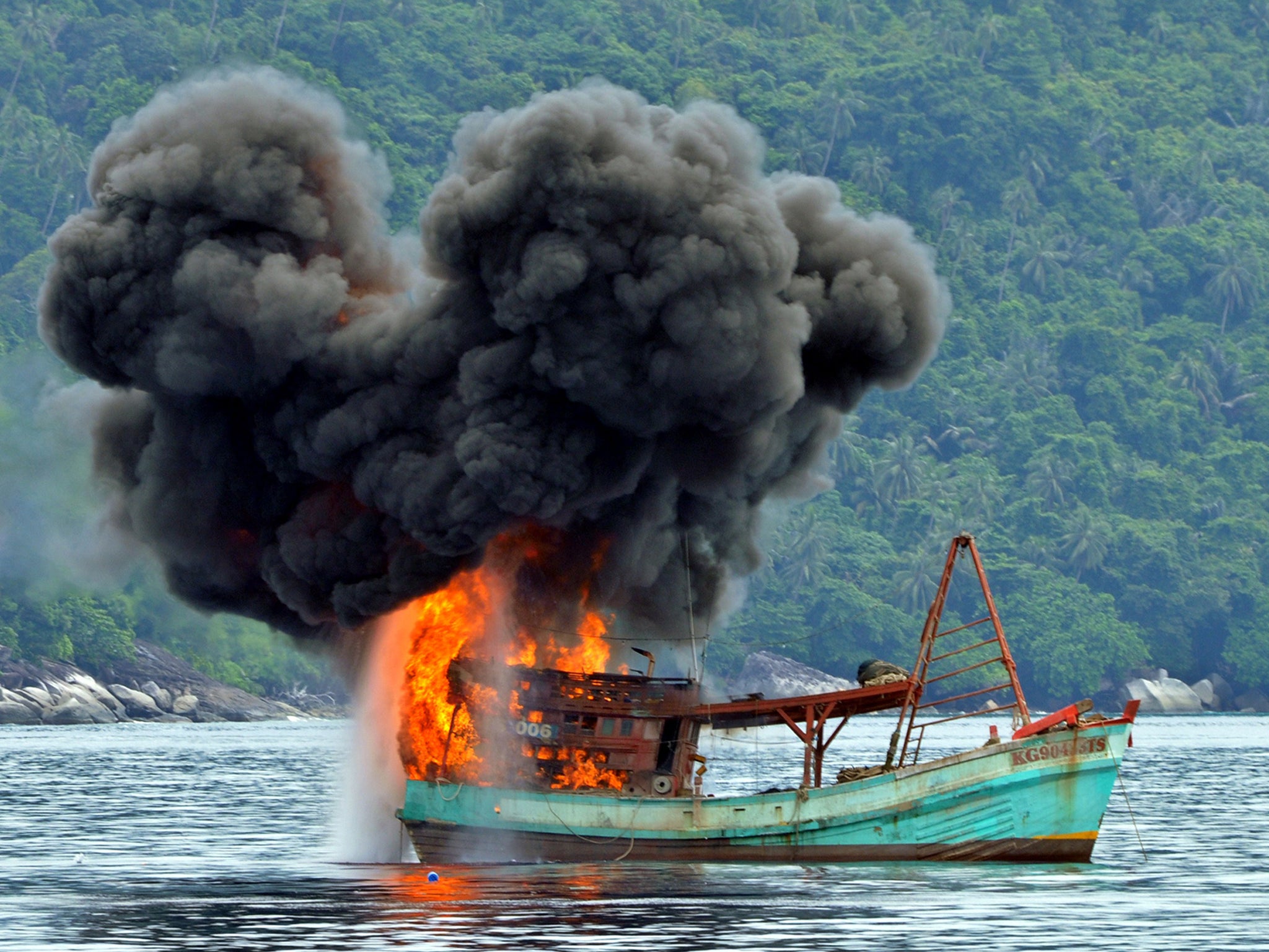 This picture from December 2014 shows a Vietnamese fishing boat in flames after Indonesian Navy officers blew up the vessel due to illegal fishing activities