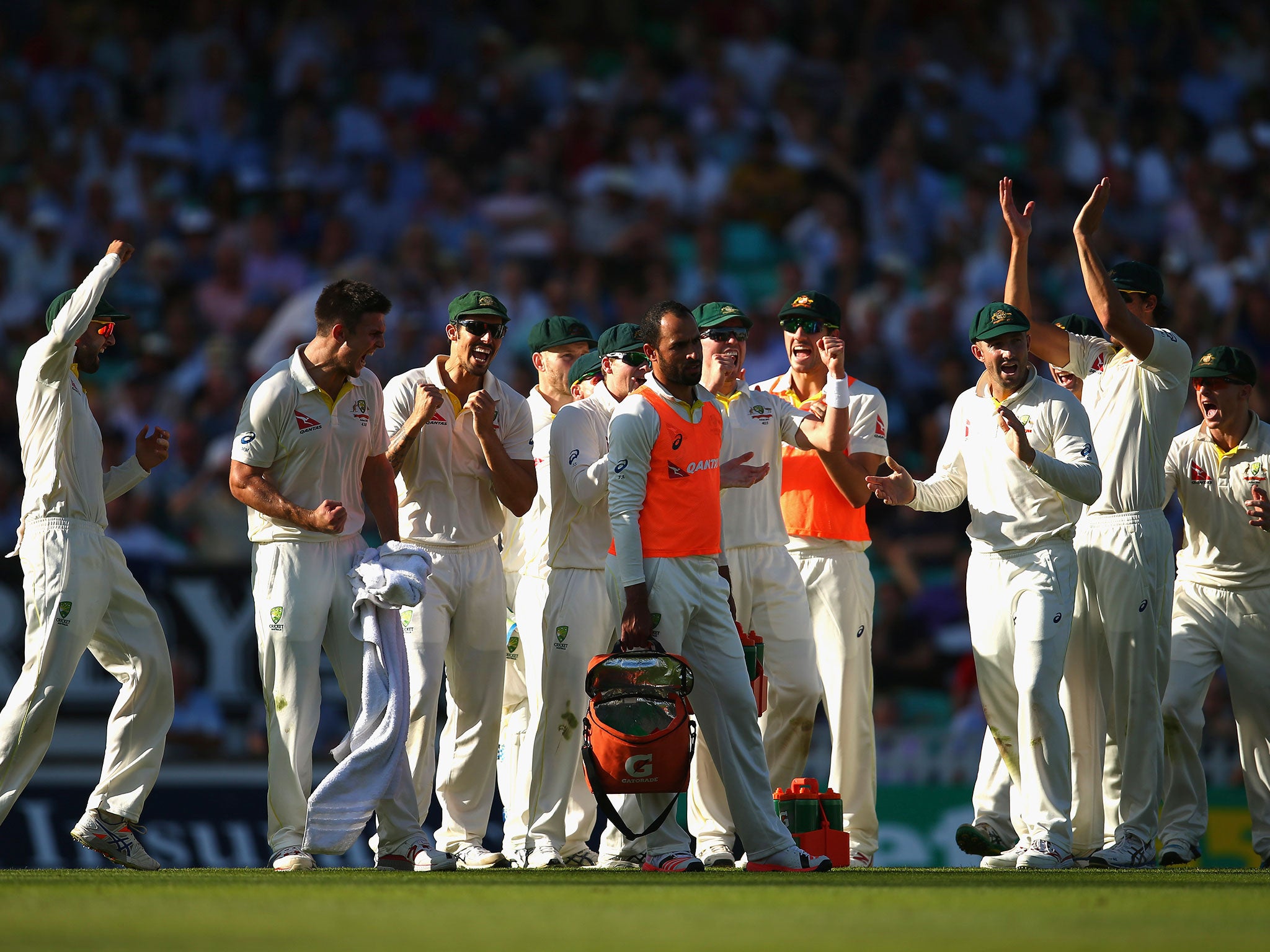 Mitch Marsh of Australia and team mates celebrates after taking the wicket of Joe Root