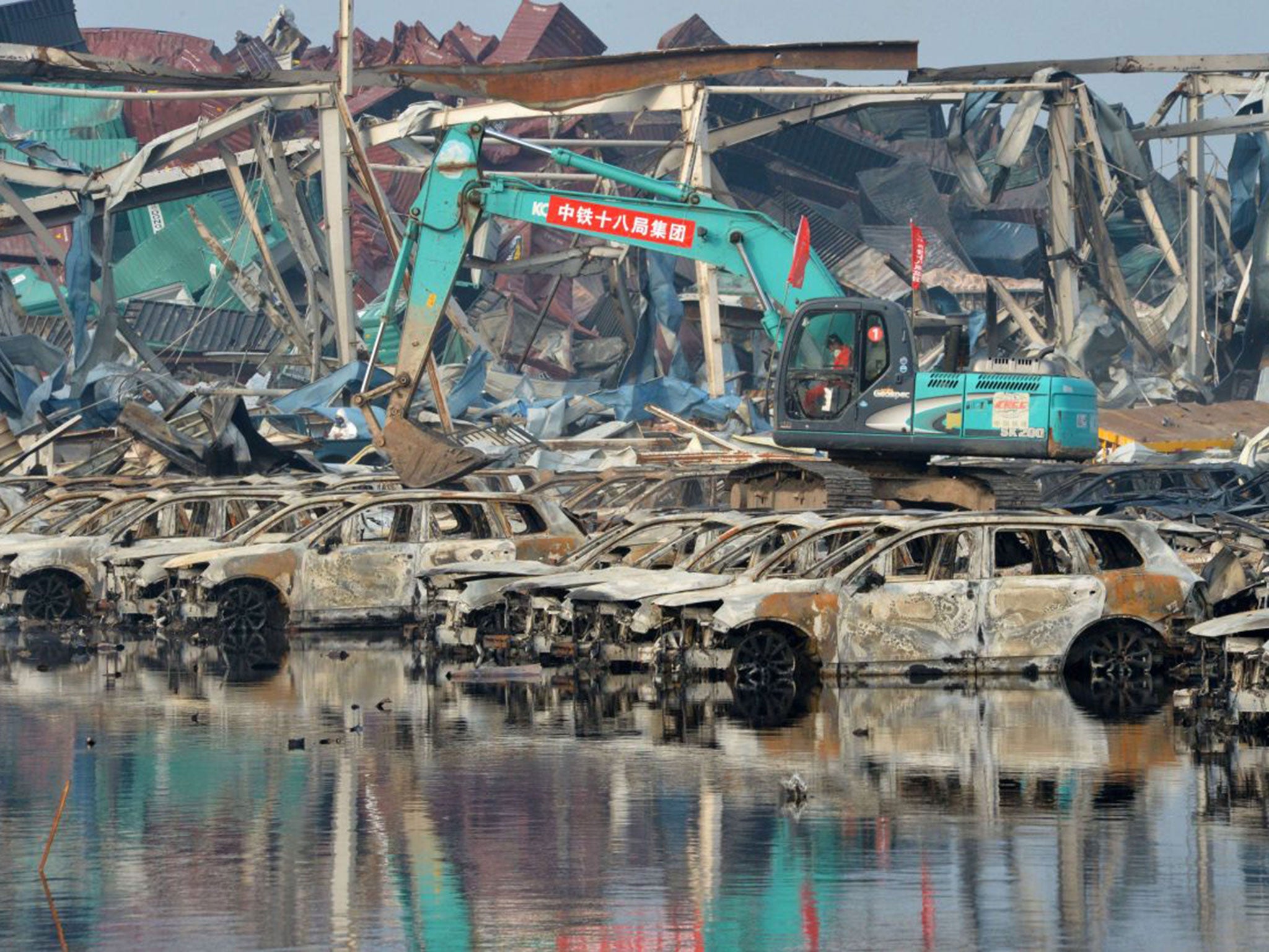 Rescuers cleaning up damaged cars at the site of the explosions