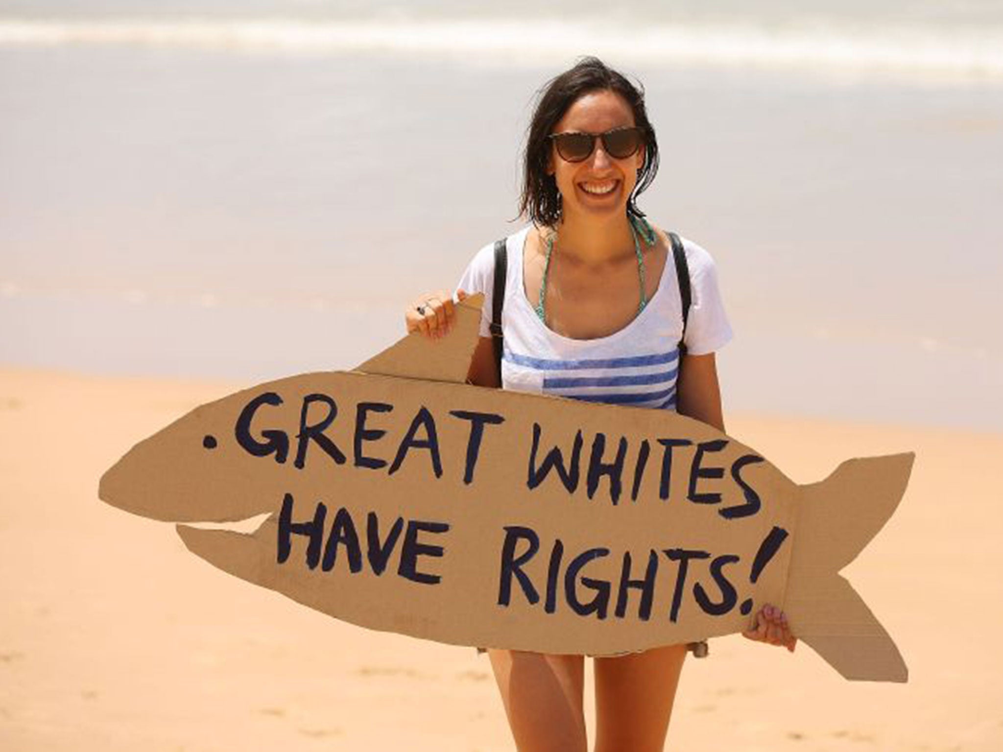 A protester holds signage against the catching and killing of sharks in Western Australia at Manly Beach