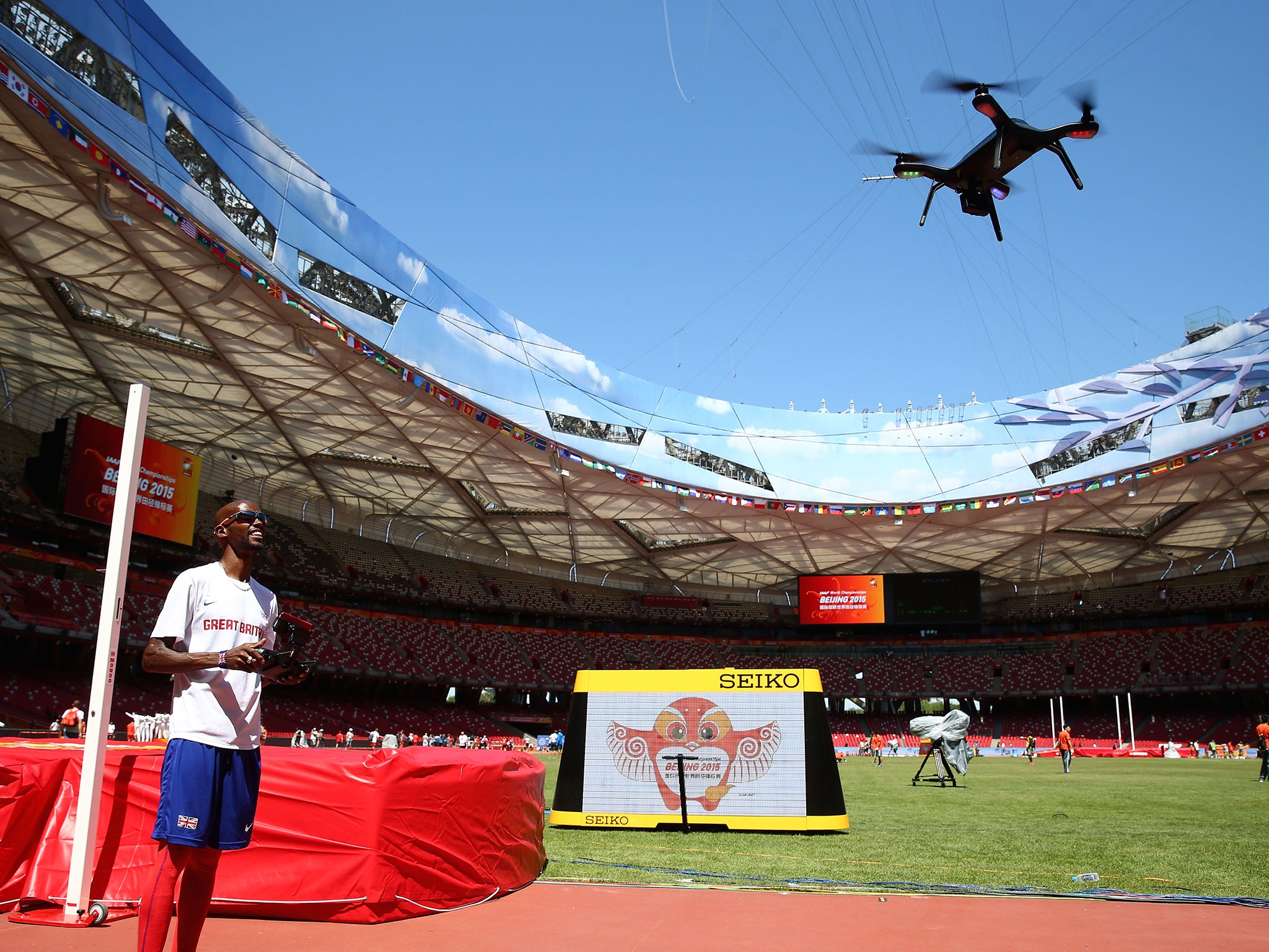 Mo Farah, of Great Britain, flies a drone during a break in practice sessions in Beijing yesterday