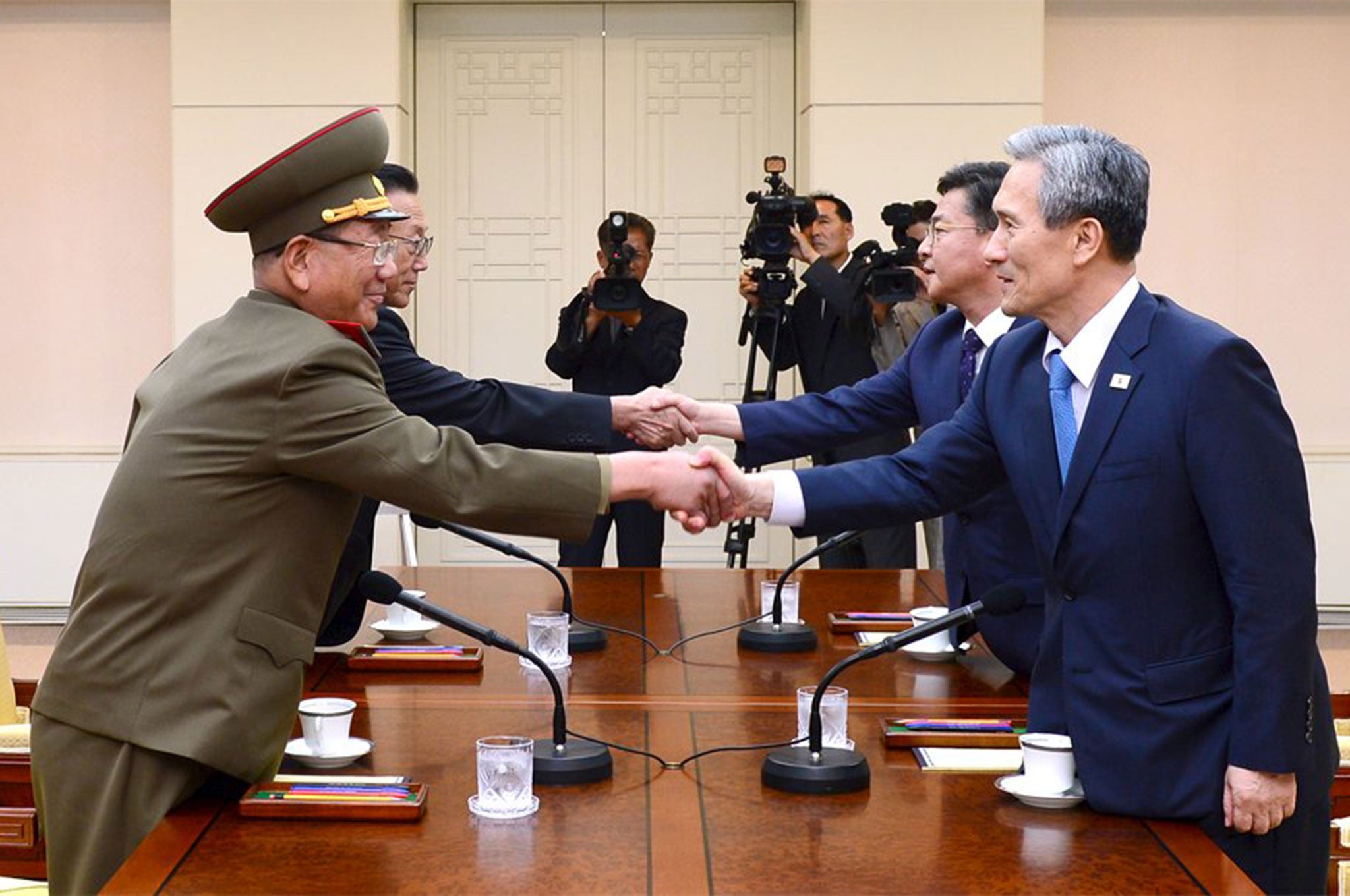 South Korean National Security Adviser Kim Kwan-jin (R), South Korean Unification Minister Hong Yong-pyo (2nd R), Secretary of the Central Committee of the Workers' Party of Korea Kim Yang Gon (2nd L), and the top military aide to the North's leader Kim Jong Un Hwang Pyong-so (L), shake hands during high-level talks at the truce village of Panmunjom