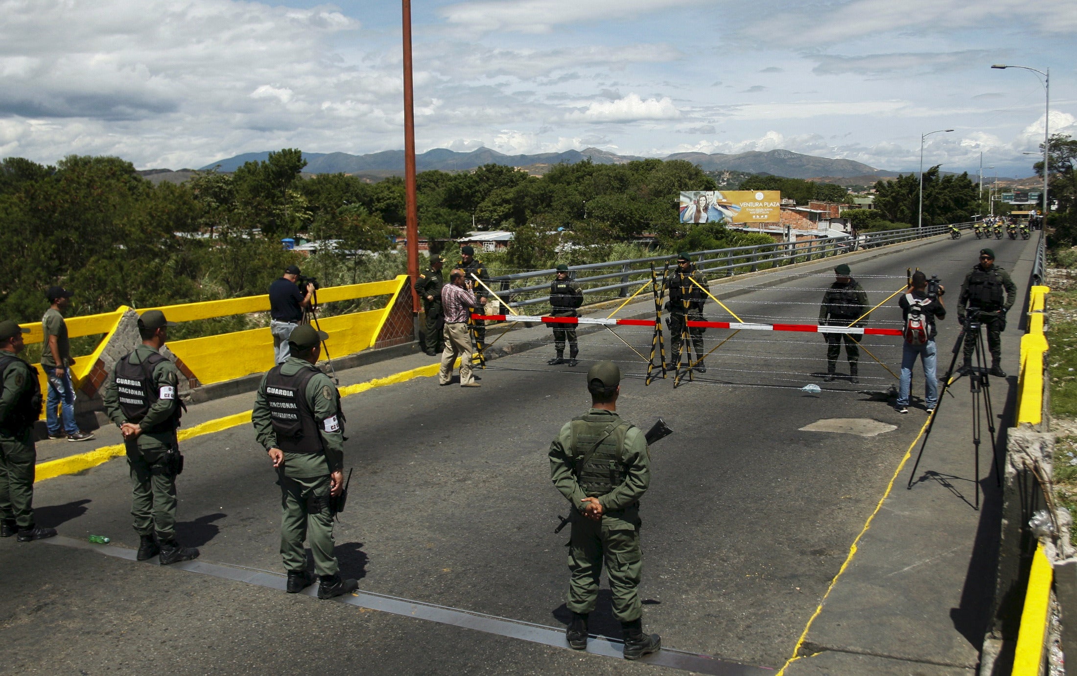 Venezuela's National Guards (bottom) stand in front of Colombia's soldiers at the countries' border
