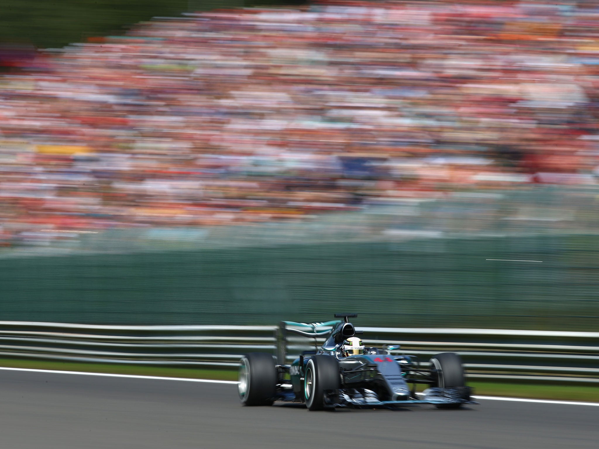 Lewis Hamilton flashes past the fans on the back straight