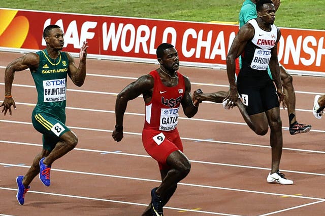 Justin Gatlin (centre) wins his 100m heat yesterday at the World Championships in Beijing 