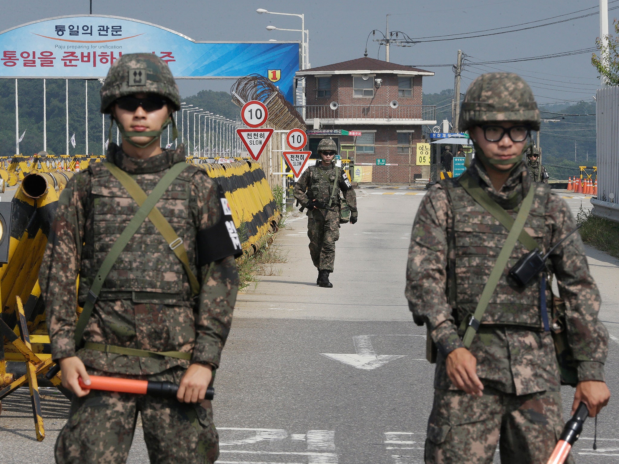 A South Korean amy soldier walks as his colleague soldiers stand guard on Unification Bridge, which leads to the demilitarized zone (AP)