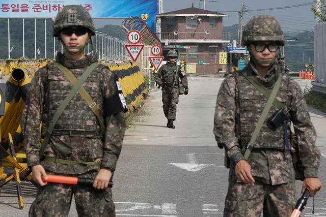 A South Korean amy soldier walks as his colleague soldiers stand guard on Unification Bridge, which leads to the demilitarized zone (AP)
